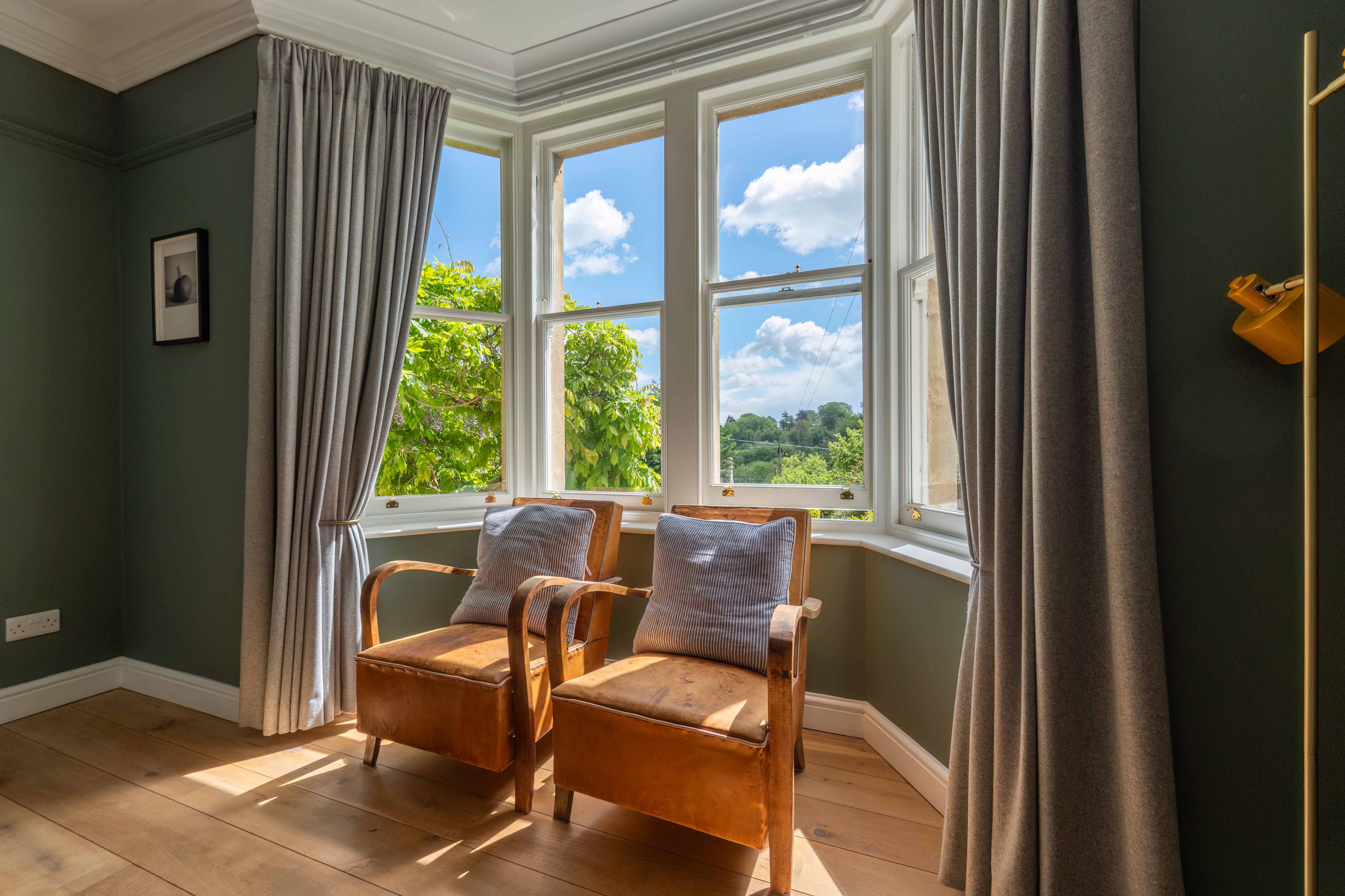 Mid-century armchairs in bay window with garden views, Georgian townhouse Bradford-on-Avon — interior photography by Captura Media