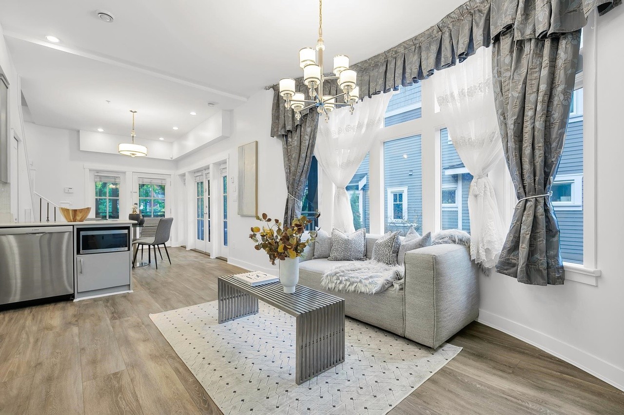 Bright, modern living room with large windows, elegant curtains, and stylish furniture. Cozy and welcoming atmosphere.