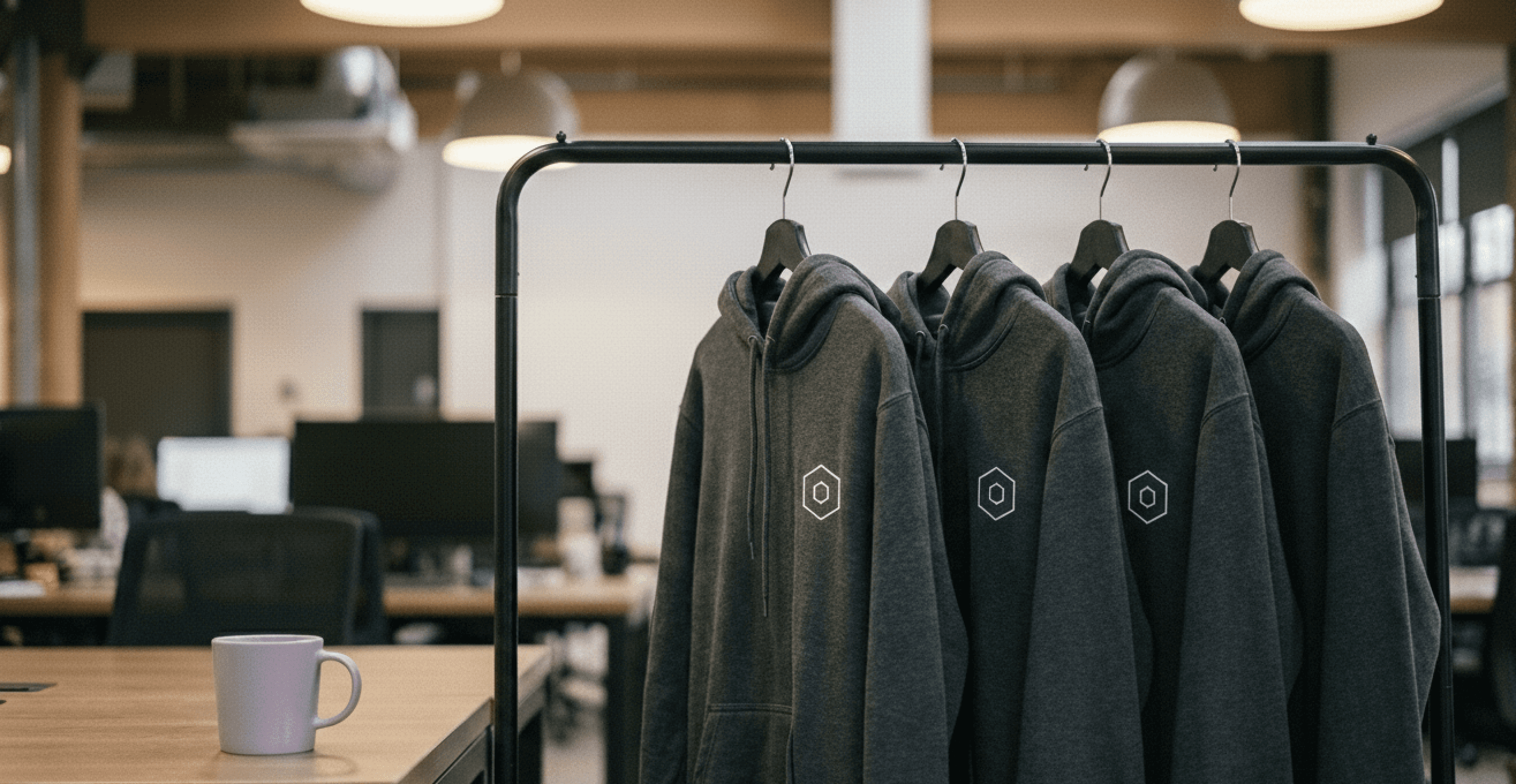 Custom printed hoodies, with the left breast logo on the rack in the clients office