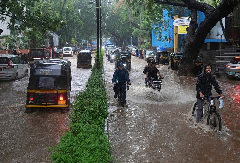 Vehicles drive through a waterlogged street during monsoon rains in Mumbai, July 1, 2026.