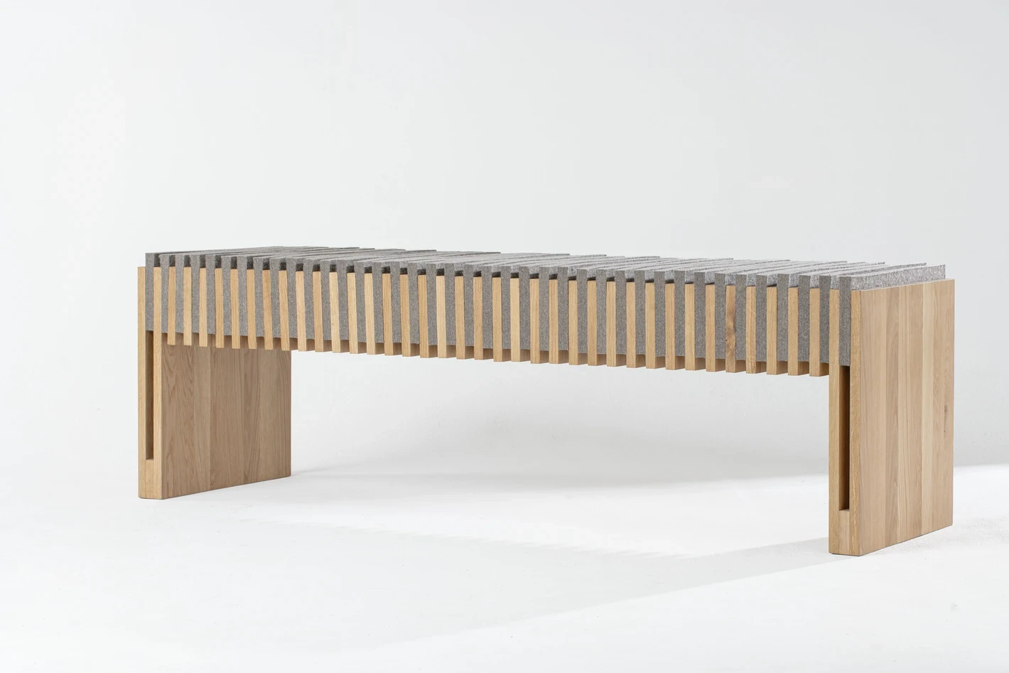 Banc architectural en bois clair, lignes horizontales et proportions épurées