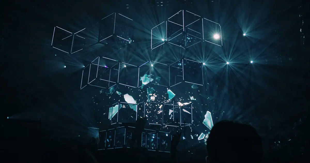 Futuristic stage design with 3D holographic cubes and immersive lighting at a live concert.