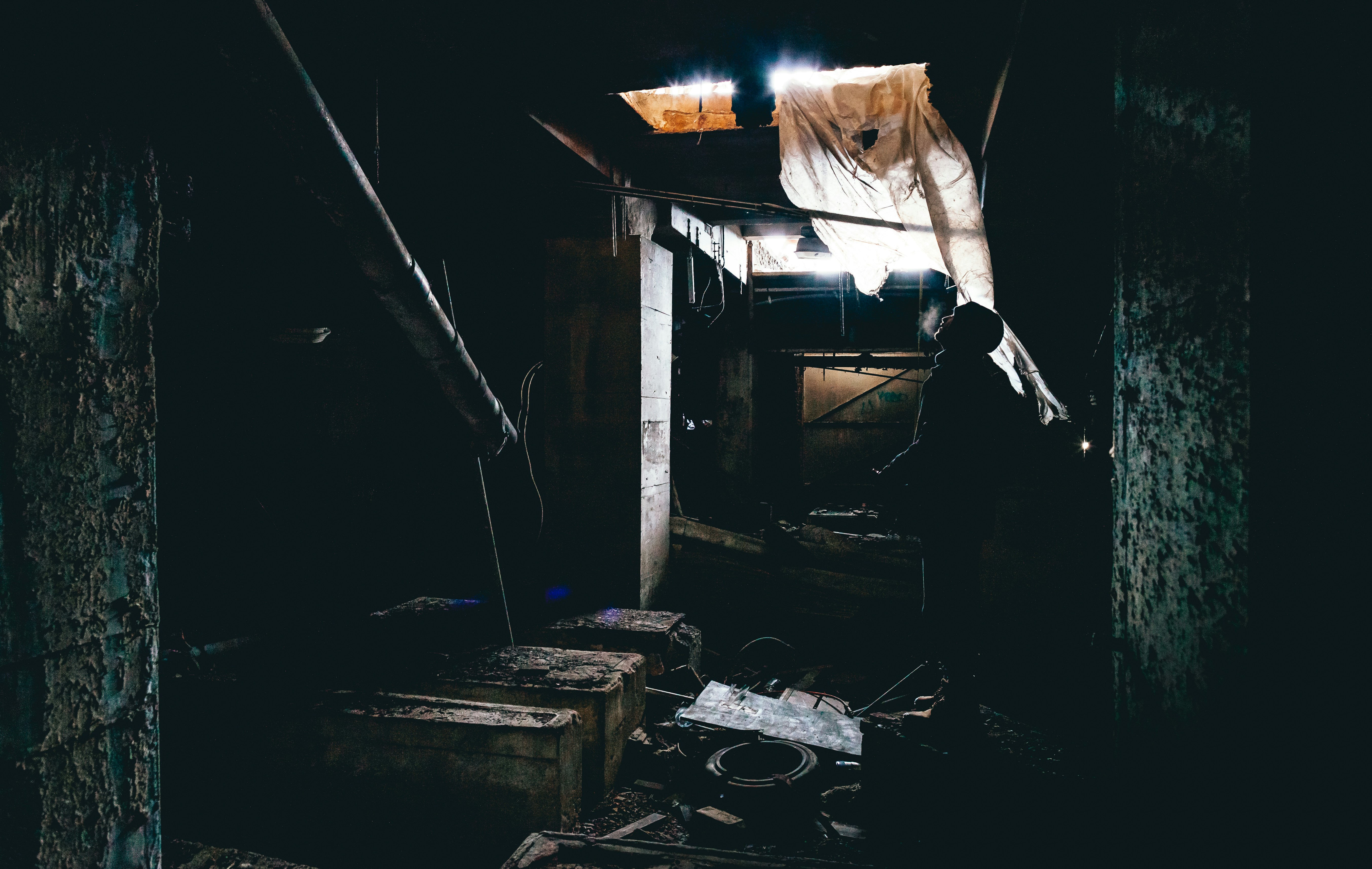 Dark crawl space lit by a single opening, the kind of place with no phone signal
