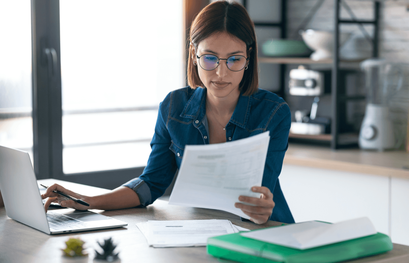 woman working with computer while consulting some documents