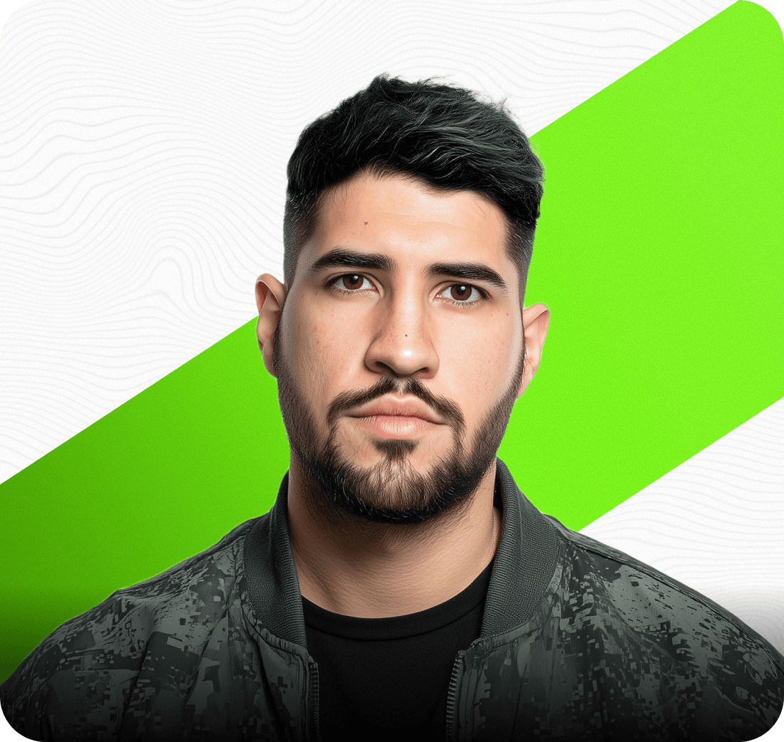 Man sitting in a dimly lit room, wearing a beige shirt and looking contemplative.