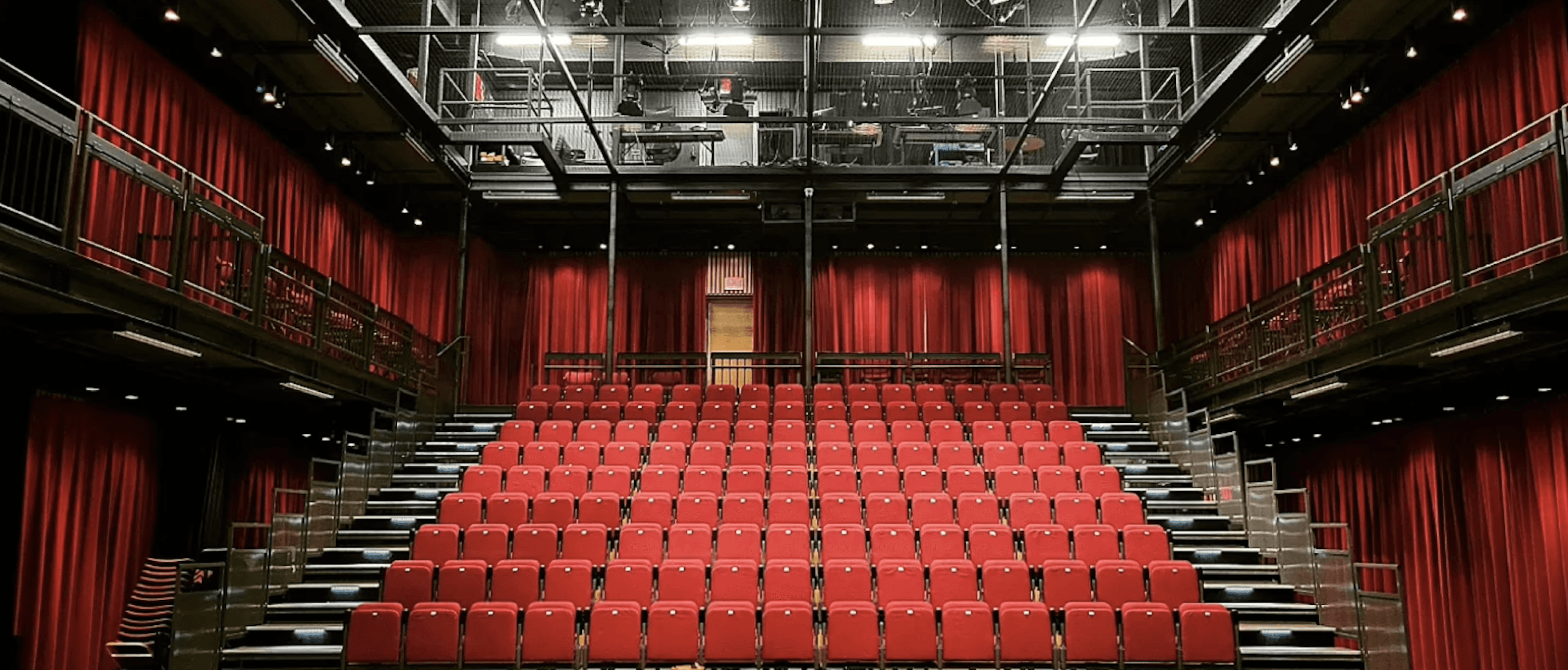 Photo of an auditorium with red seats 