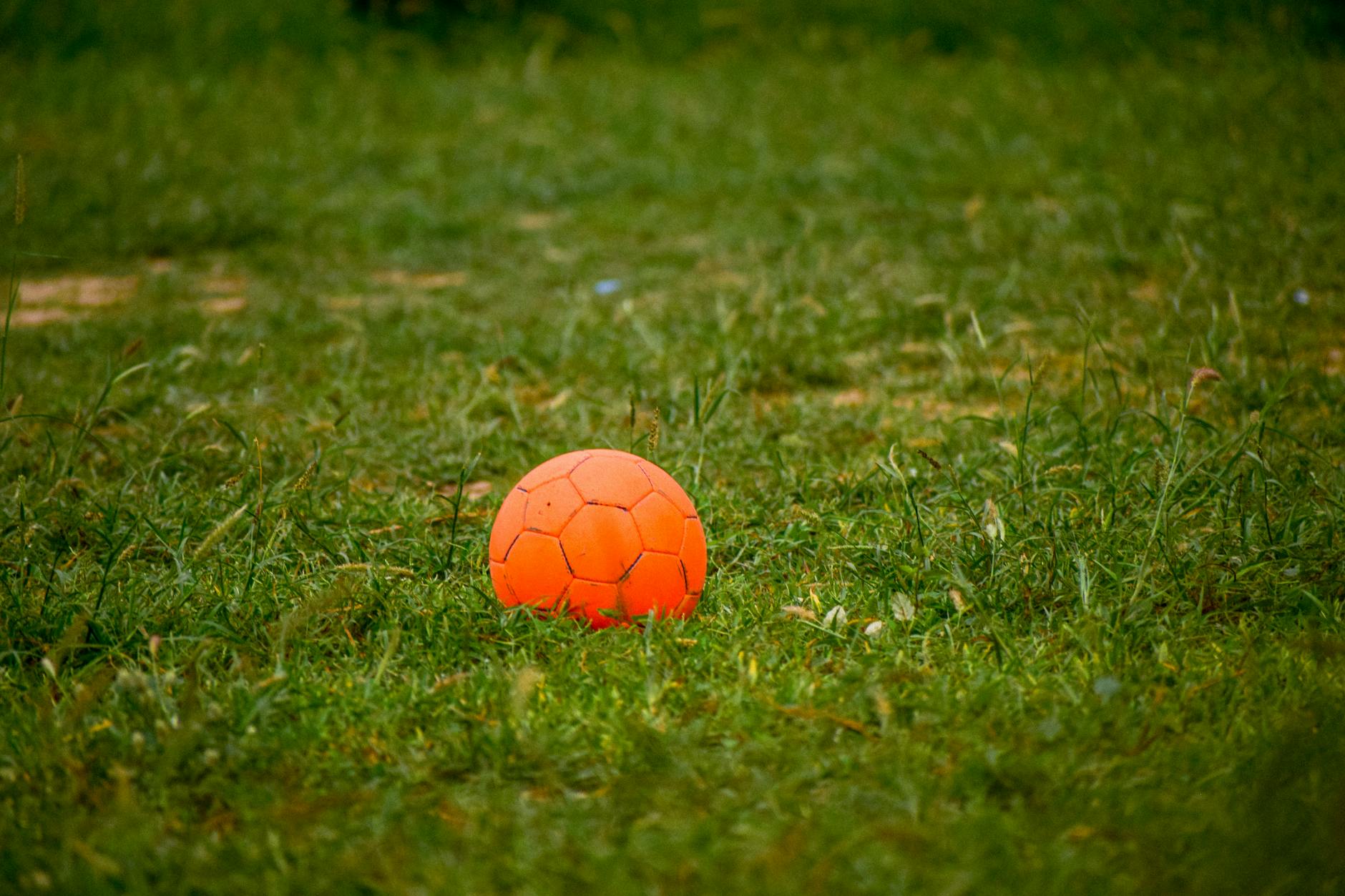 Students using rolled-up socks and plastic buckets for a modified tossing game in a small classroom space.