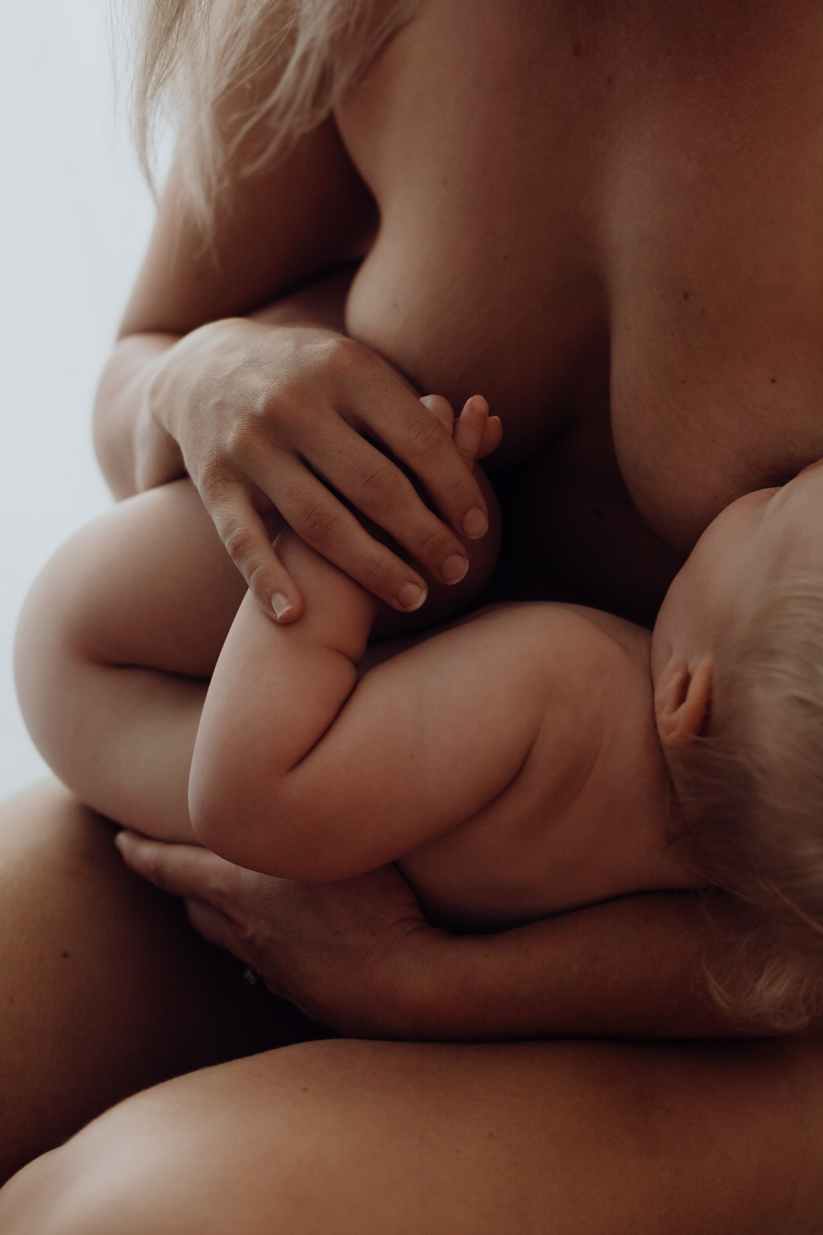Mother breastfeeding her baby during a natural light motherhood photography session in Mackay, Queensland.