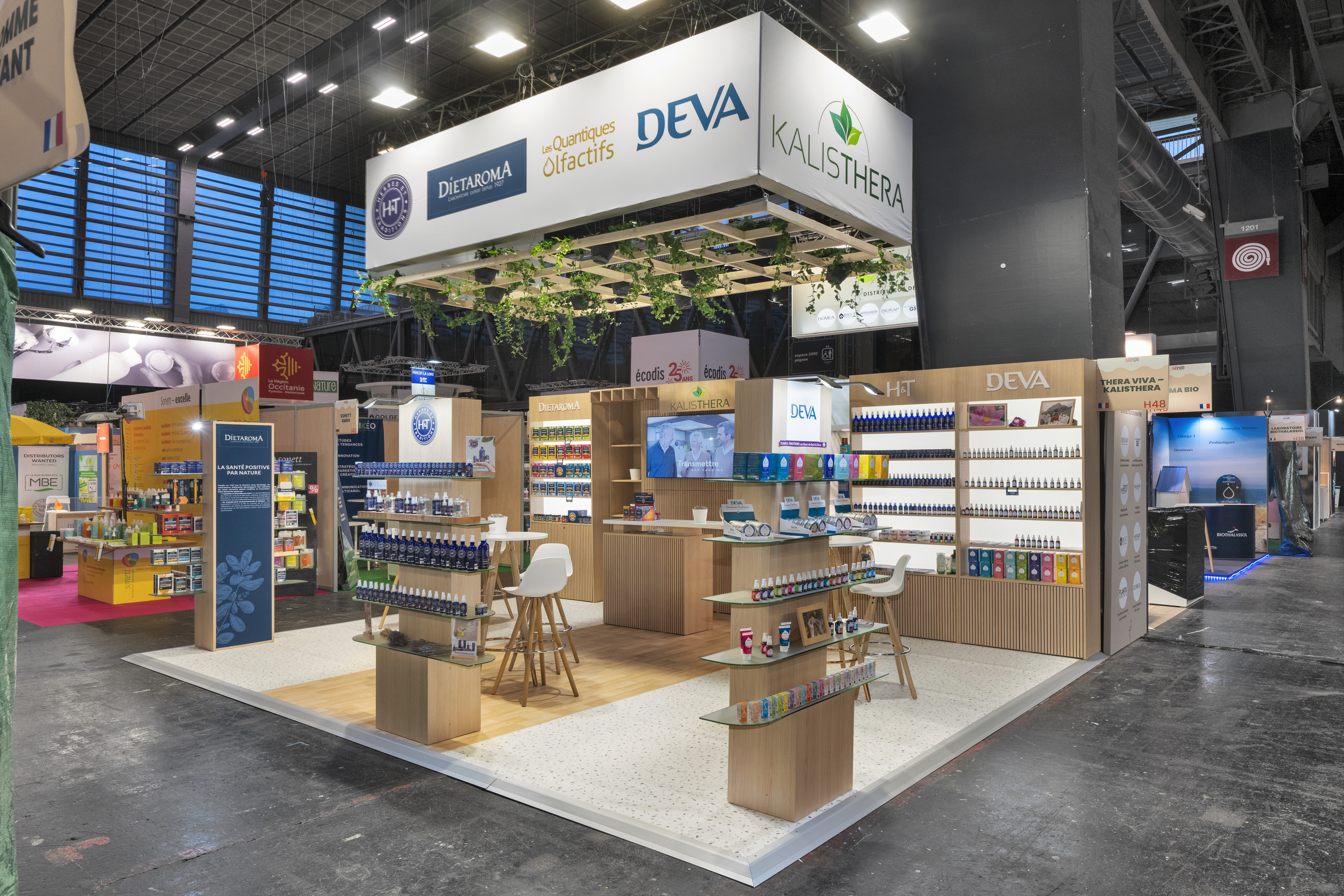 Stand Alma Bio Distributeur Natexpo 2025 – vue d'ensemble aménagement stand sur-mesure bois et blanc avec linéaires produits bio, réalisé par Expace