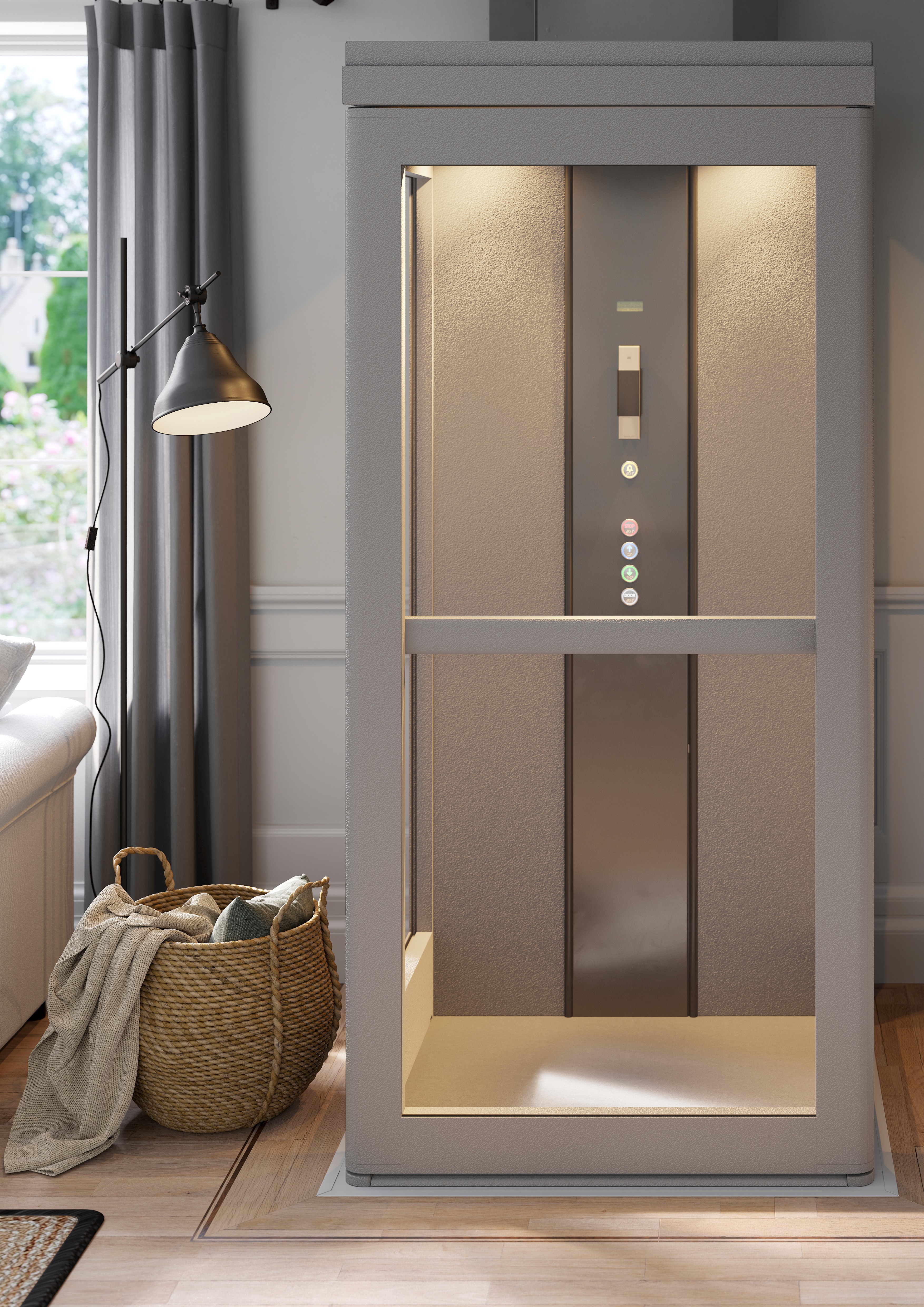 A through-floor home lift in grey finish with a lit interior cabin, installed in a domestic living room setting, showing the control panel and open shaft design.