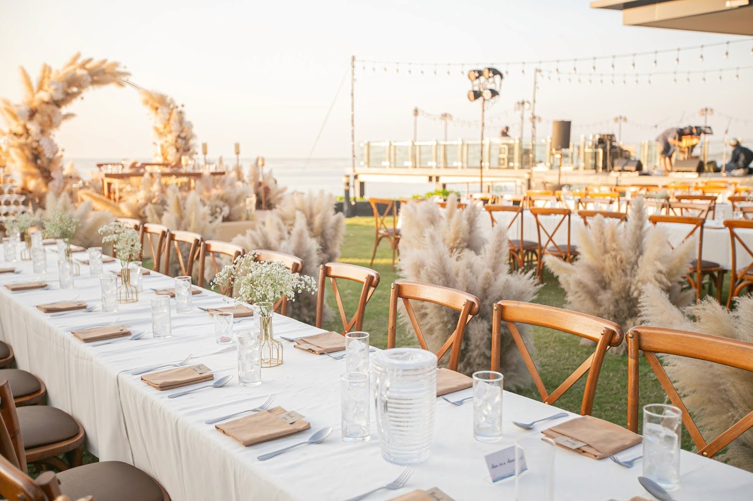 Outdoor wedding reception table set with natural linens and delicate flowers in garden setting