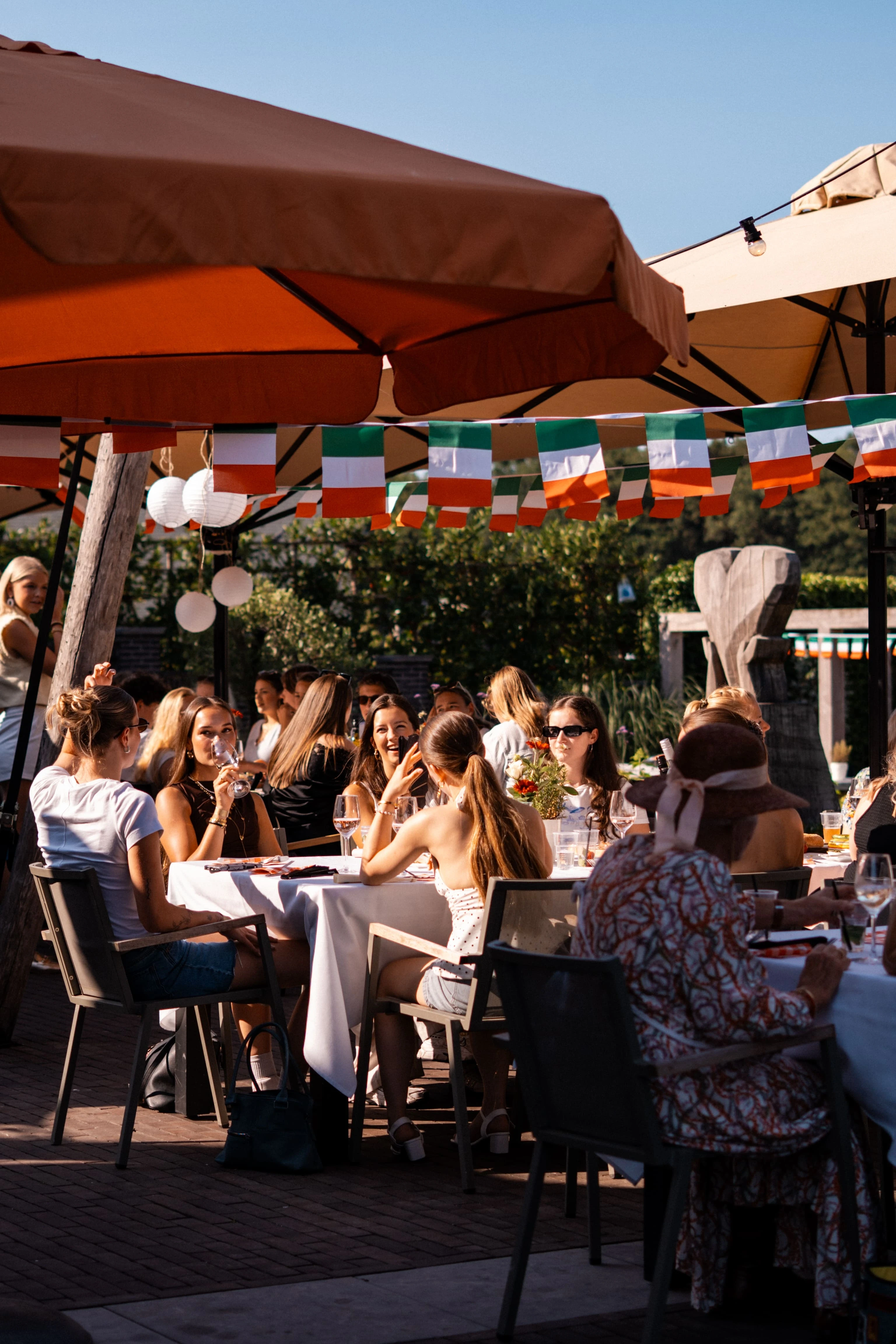 Vol terras onder parasols met Italiaanse vlaggetjes