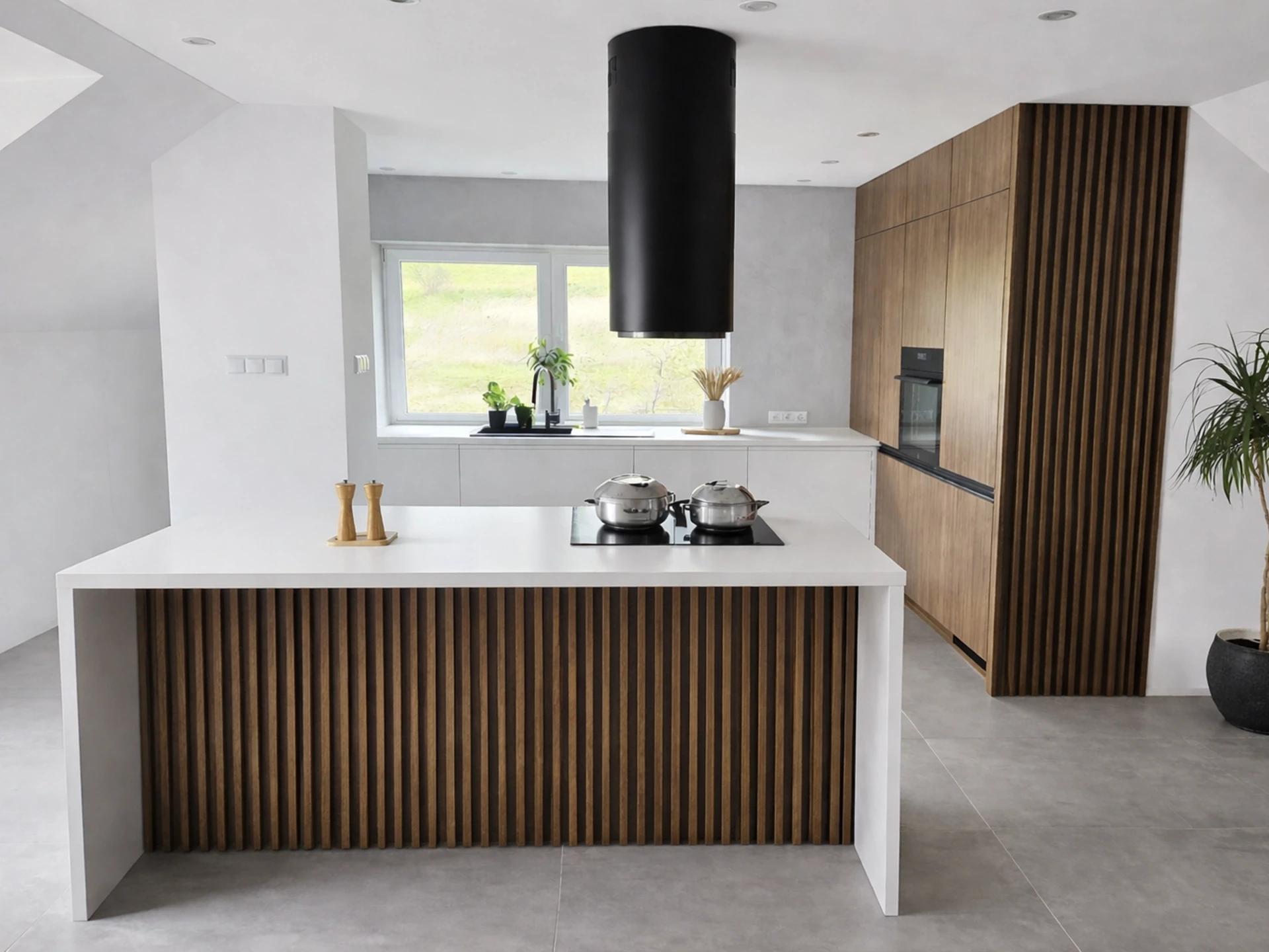 Nowoczesna wyspa kuchenna z lamelami i czarnym okapem tubą w jasnym wnętrzu.