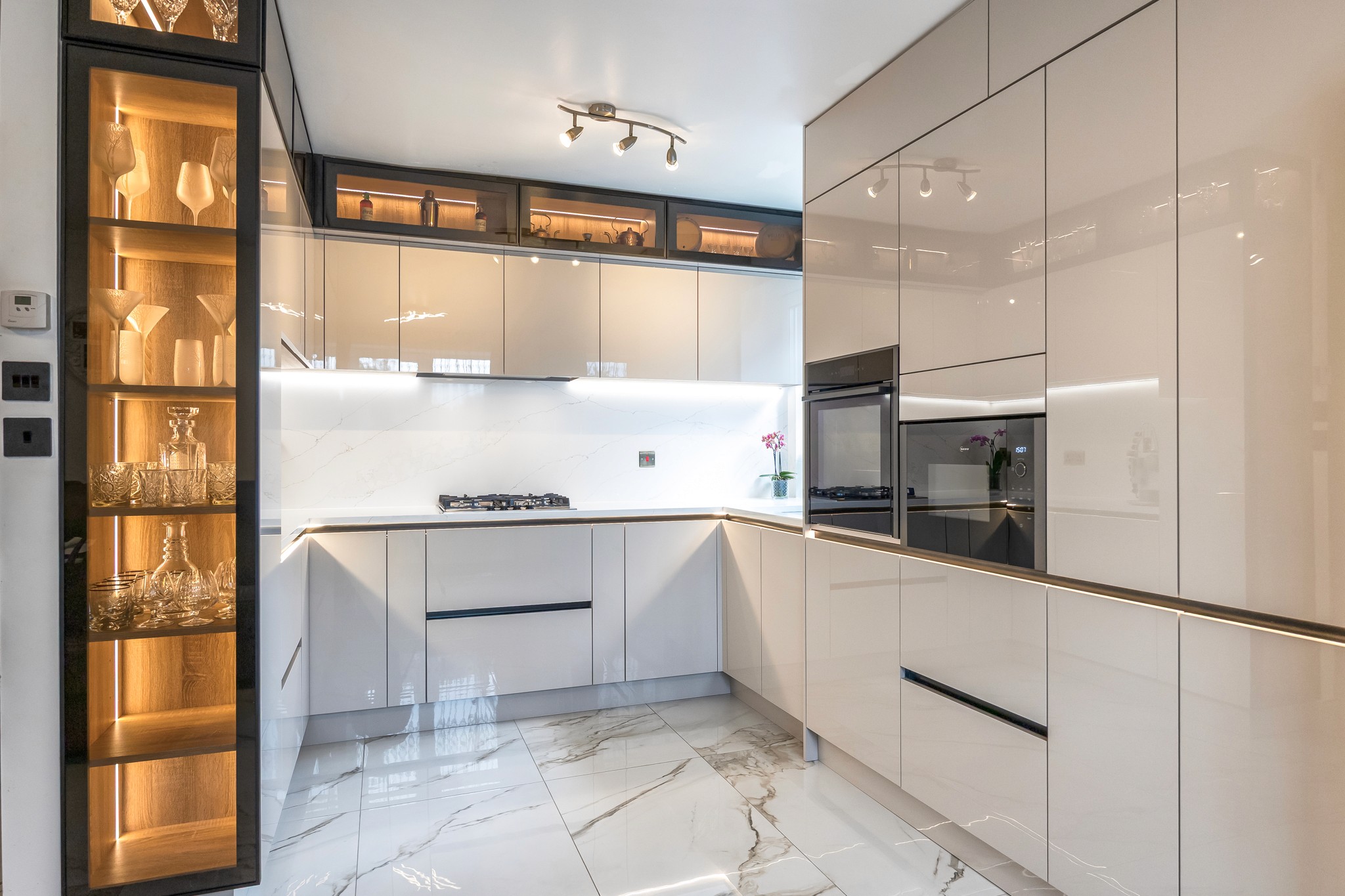 Modern indoor space with large glass doors, lush greenery, and a cozy seating area visible beyond.