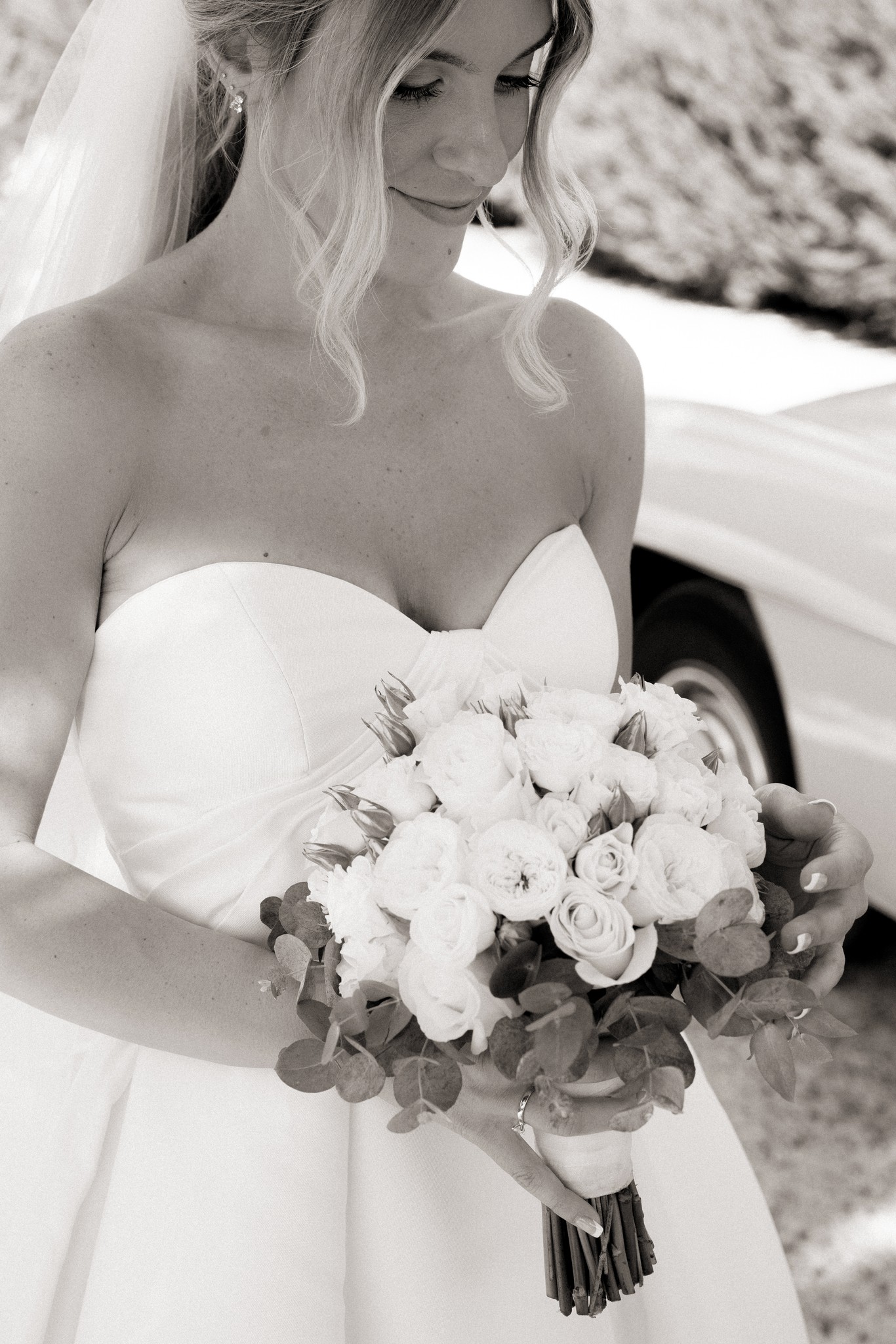 Sposa in abito bianco con bouquet di rose e eucalipto a Bolgheri, ritratto di matrimonio in bianco e nero
