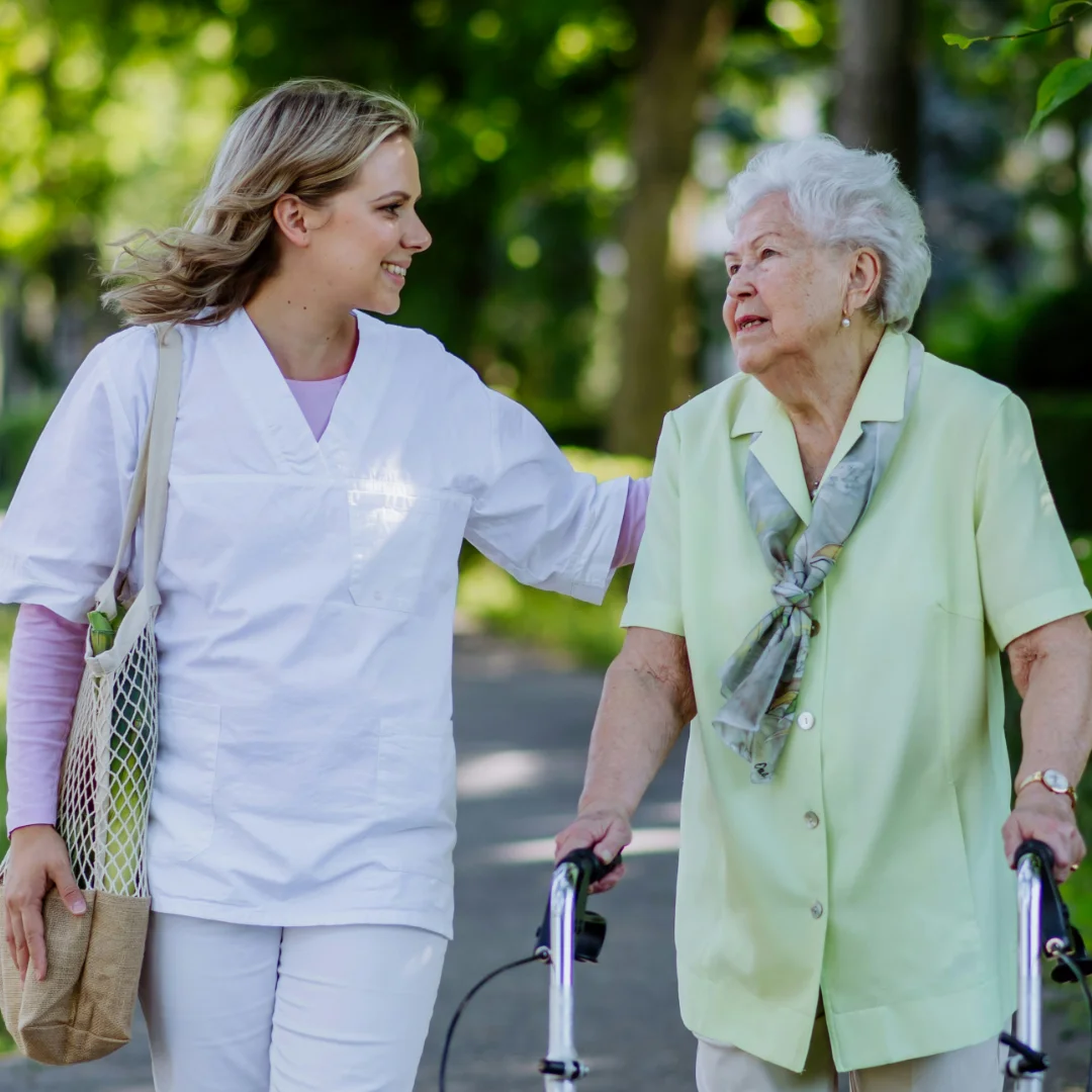 Nurseco community nurse supporting older woman walking outdoors in Brisbane