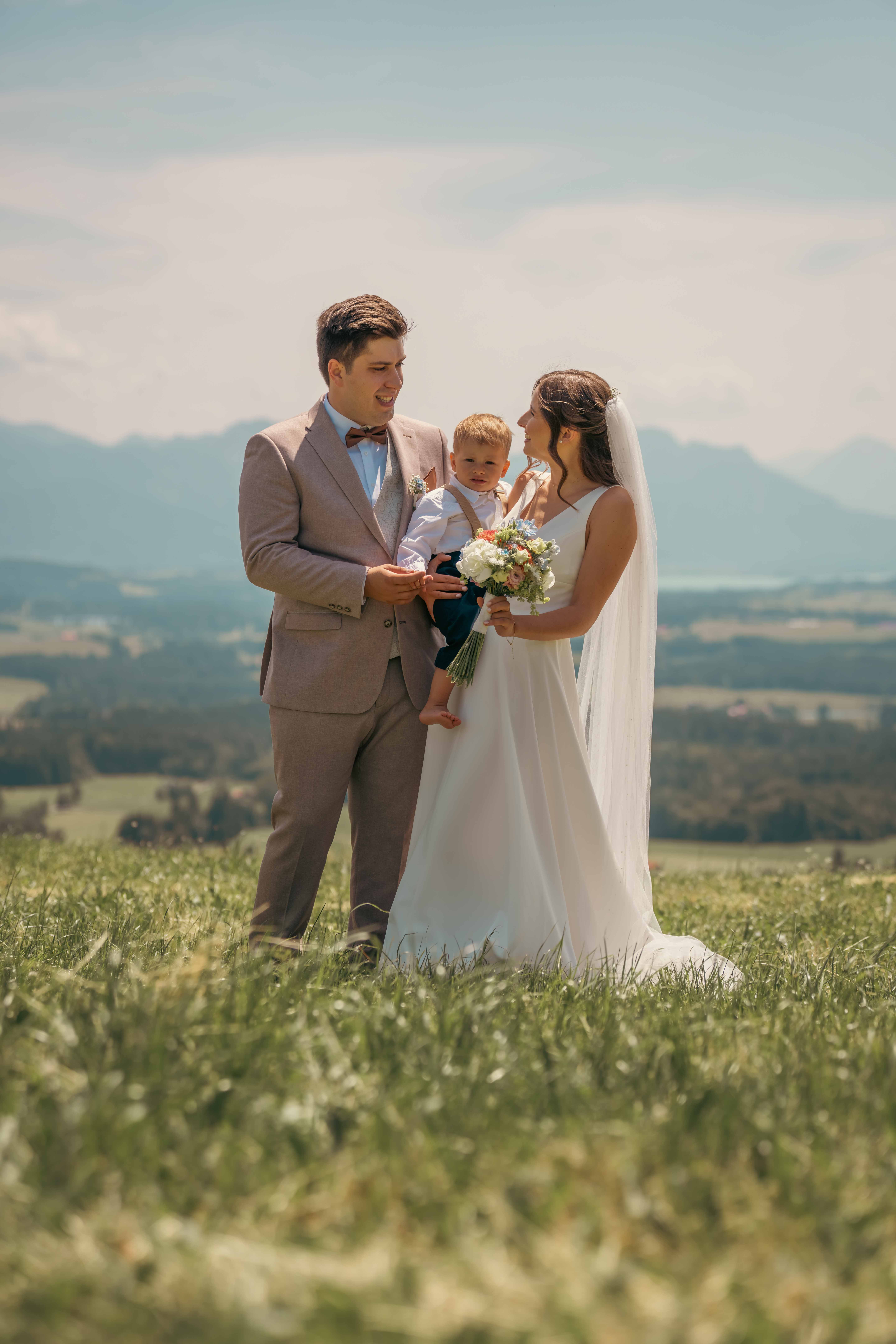 A bride in a lace wedding dress gently holds.