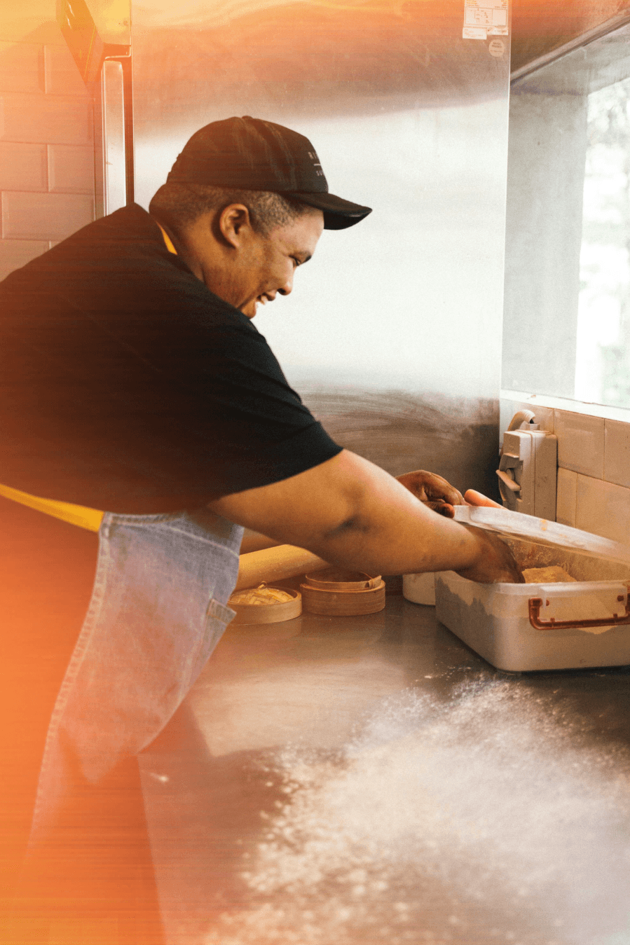 A hospitality worker preparing food in a commercial kitchen