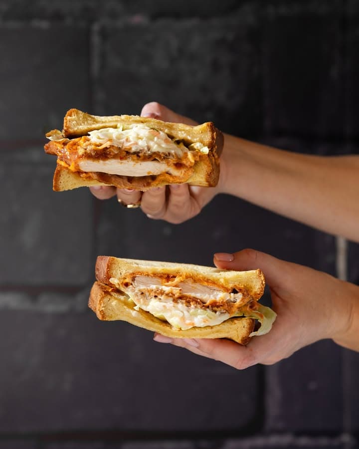 Crispy schnitzel bread with meat, perfect for weekend breakfast in Dubai food hall at Social Distrikt, offering flavourful bites.