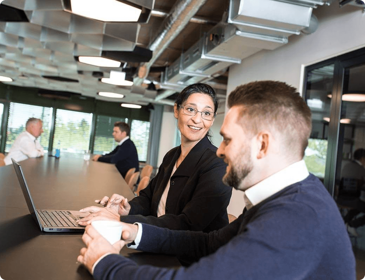 Sovendus Legal team members chatting animatedly at a table in the office