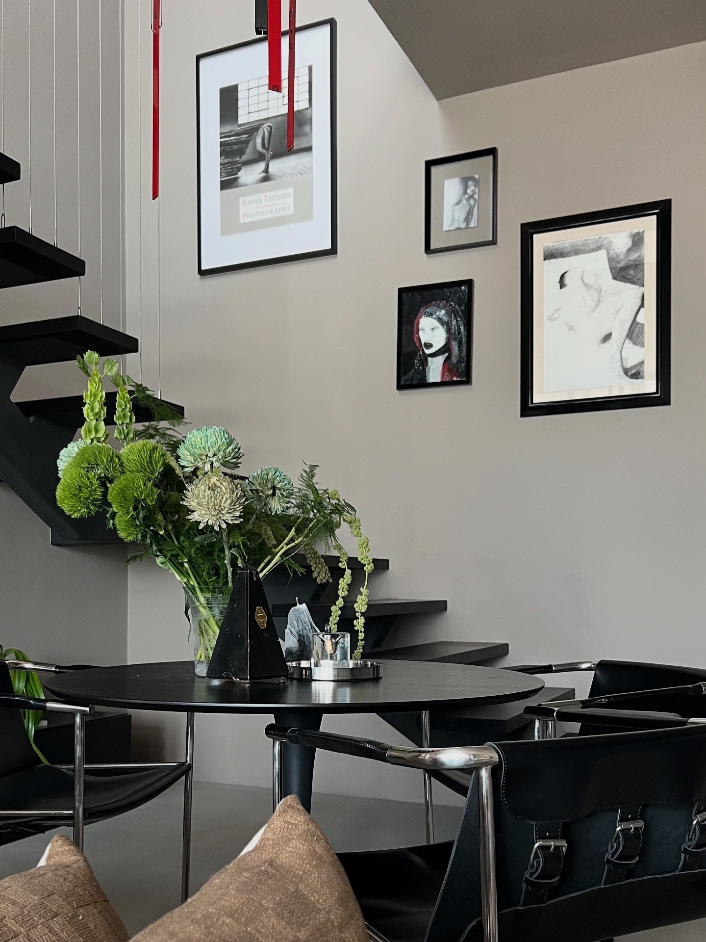 A softly lit hallway with a series of arched doorways, warm-toned walls, and wood flooring leading toward a seating area with neutral furniture.