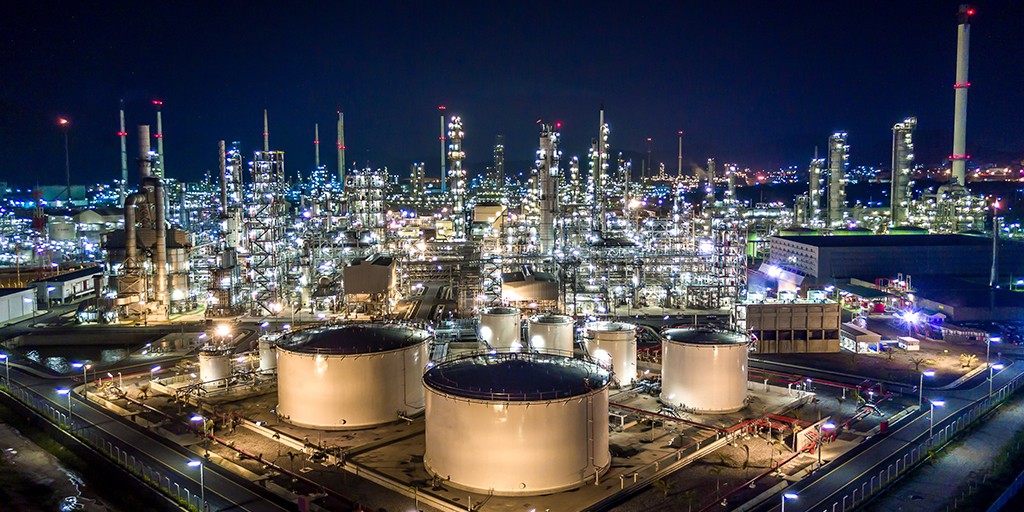 Industrial oil refinery with tall distillation towers and complex piping systems