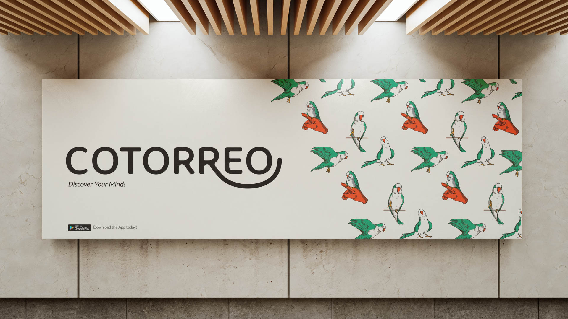 A rectangular billboard displays a repeating pattern of green and orange parrots perched on wooden branches against a light beige background. The word "COTORREO" is prominently displayed in black letters above the phrase "Discover Your Mind!" and a smaller "Download the App today!" at the bottom. The billboard is mounted on a light-colored wall beneath a wooden slatted ceiling.