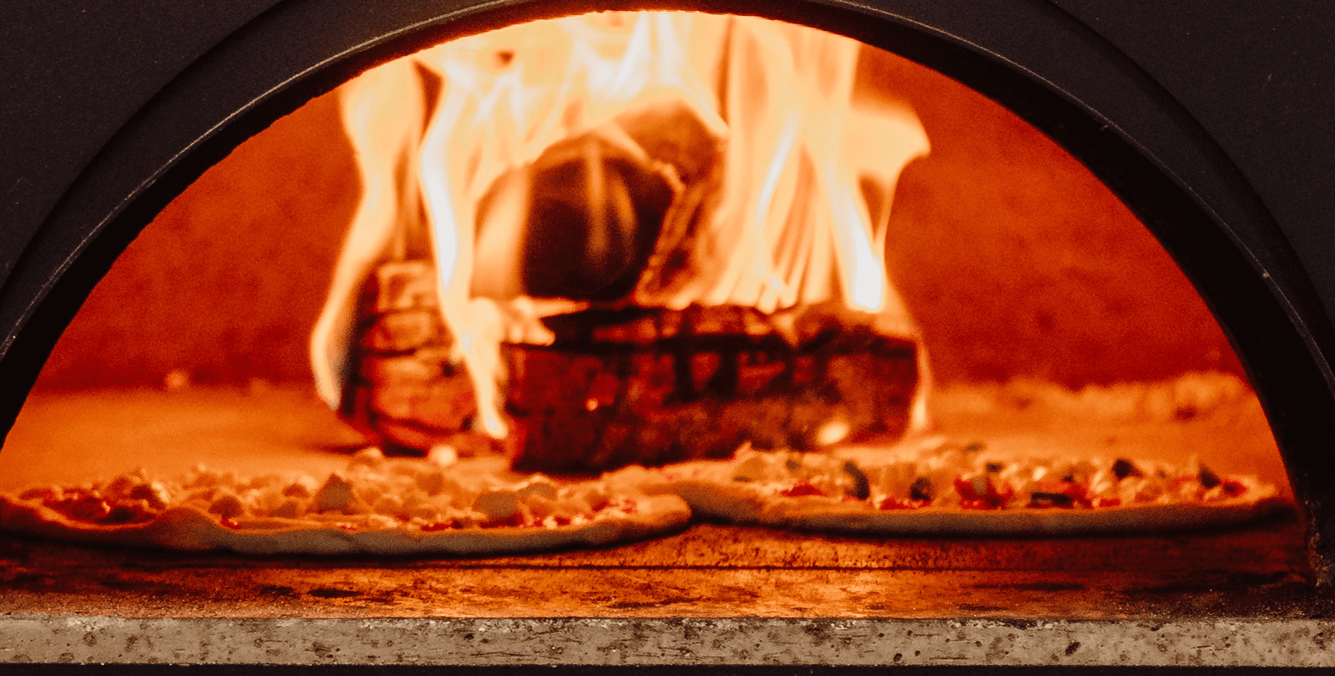 pizzas in a wood-fired oven