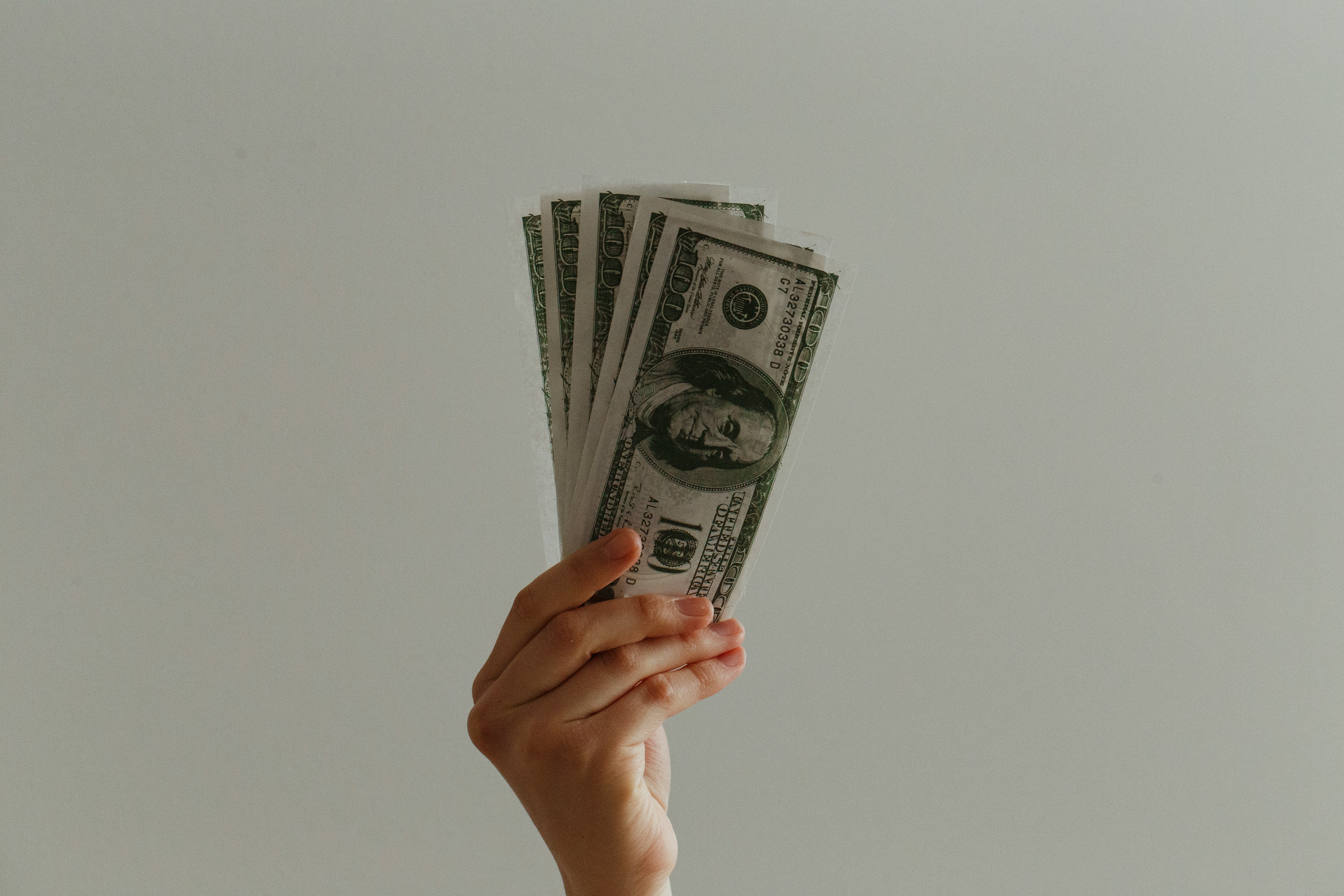 person holding money in hands - how to write R&B songs