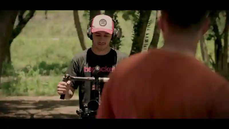 Behind-the-scenes shot of a camera operator filming an interview outdoors.