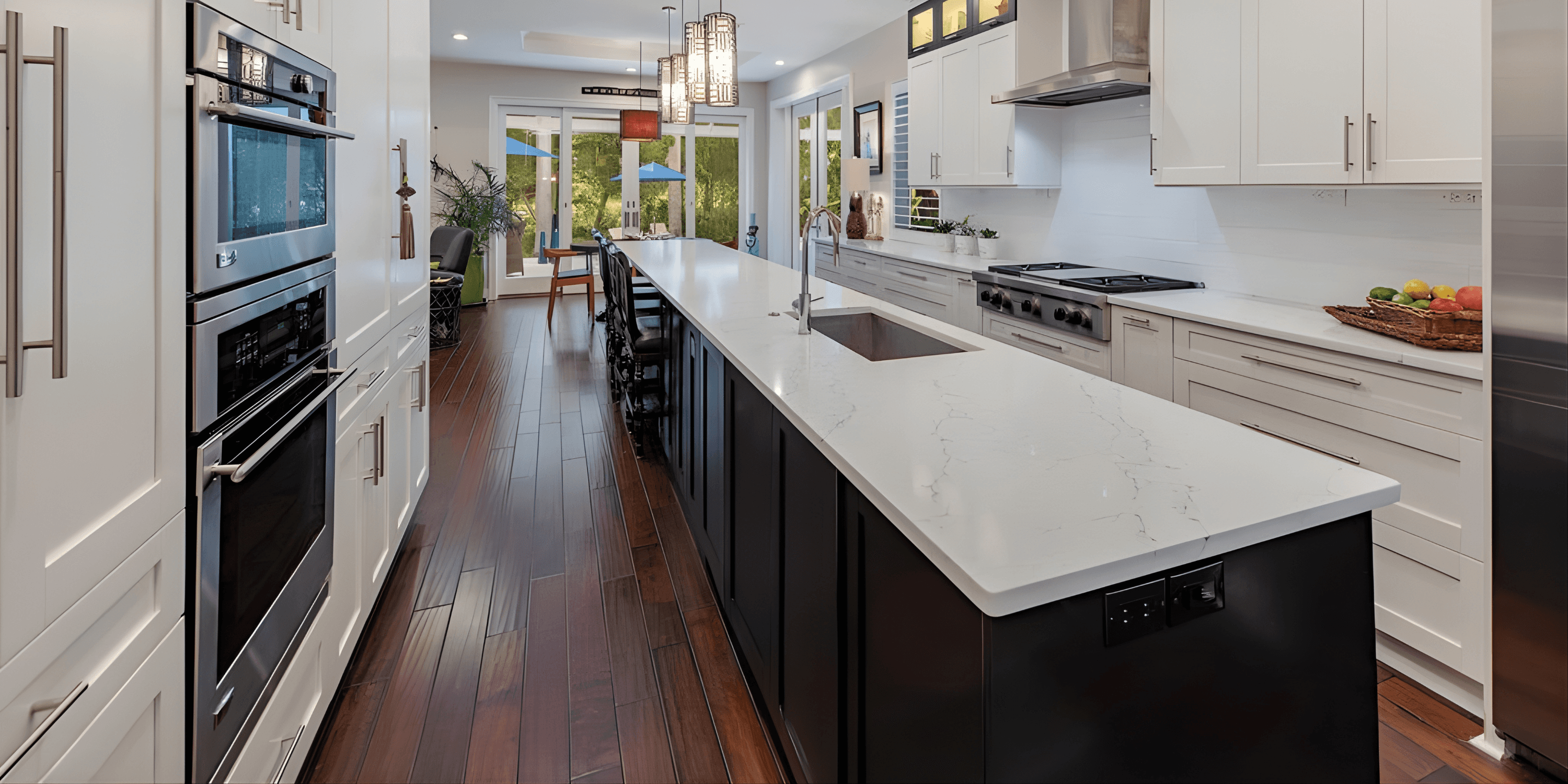 a modern kitchen with black cabinets, brown wood floors, and white countertops