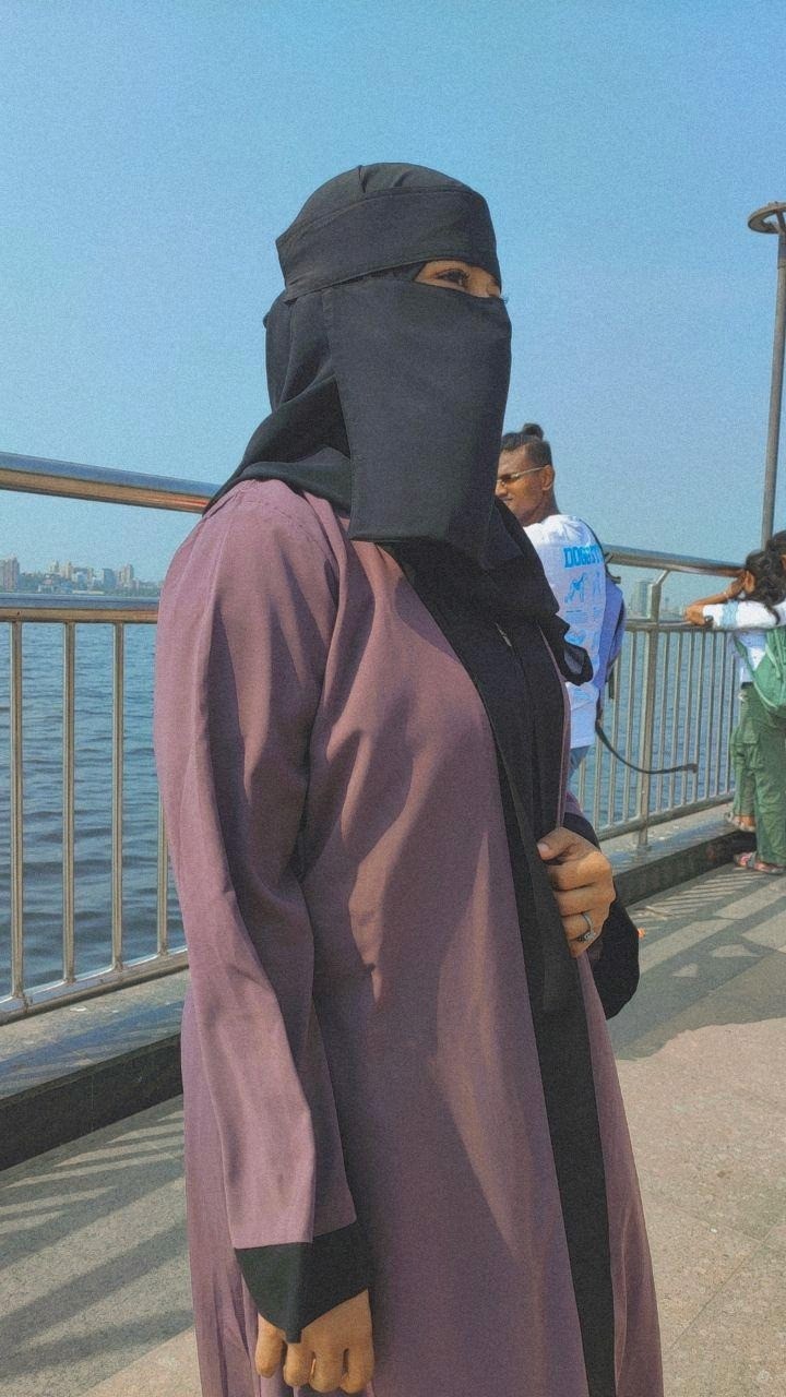 Close-up of a dark green leaf showing its textured surface and central vein against a muted background.