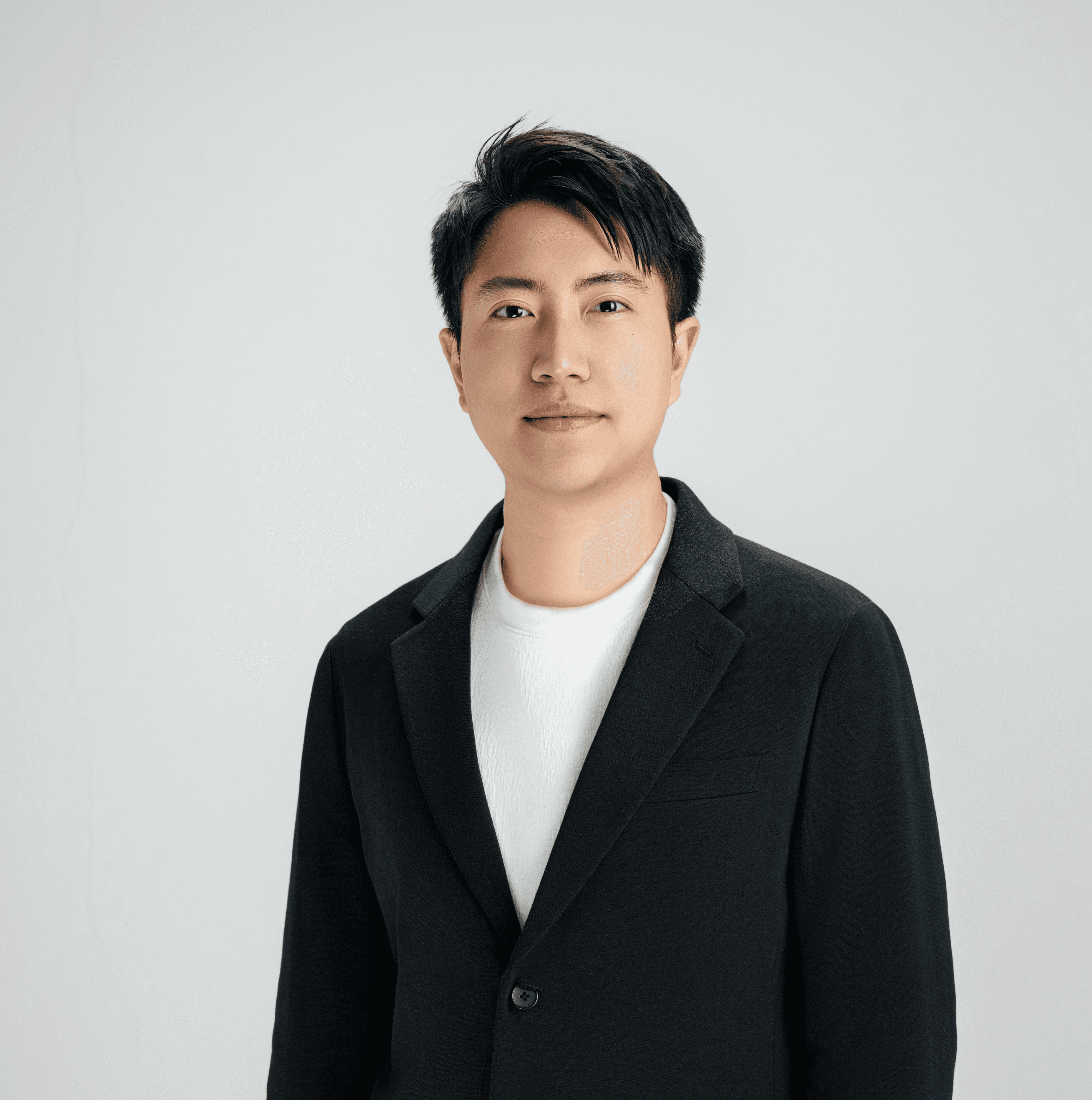 A man smiles, dressed in a blazer.