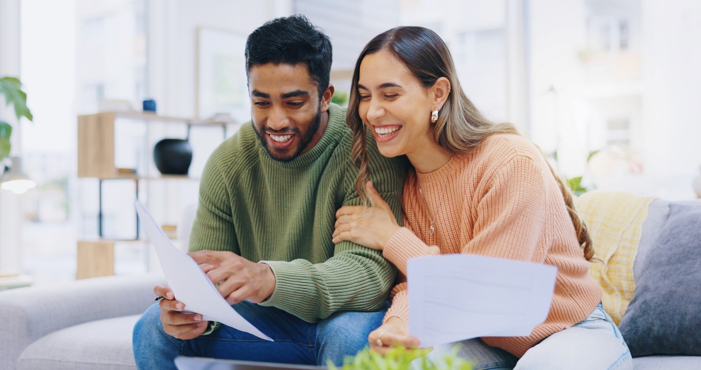 Happy young couple reviewing paperwork