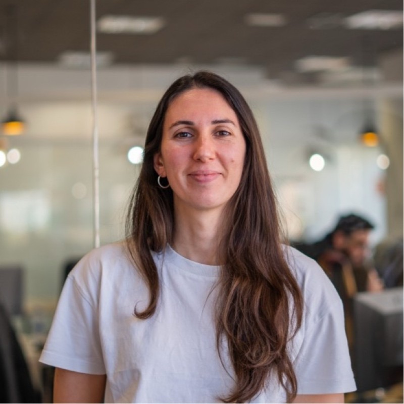 Donna con lunghi capelli castani che sorride in ufficio