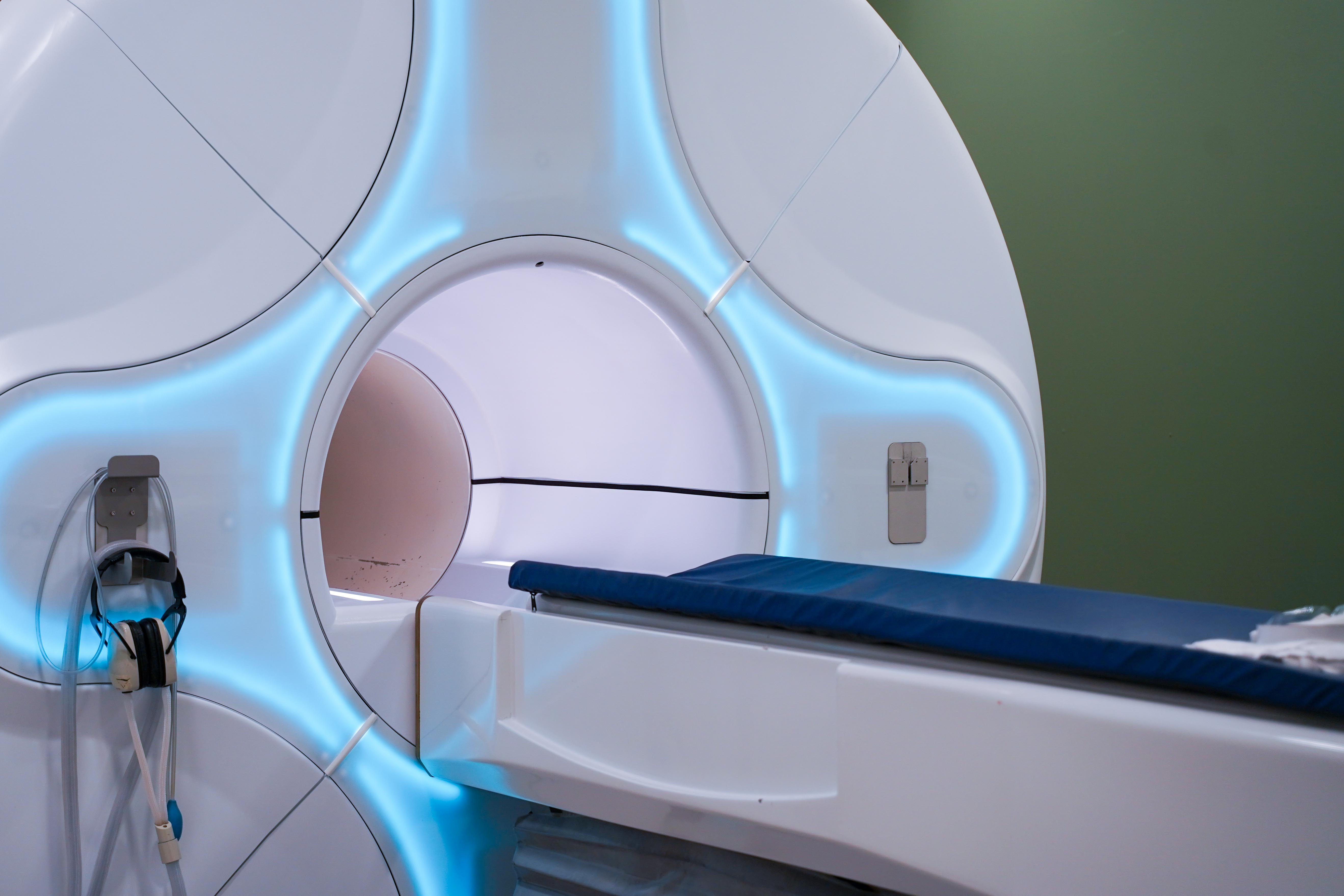 A MRI machine with a glowing blue outer ring