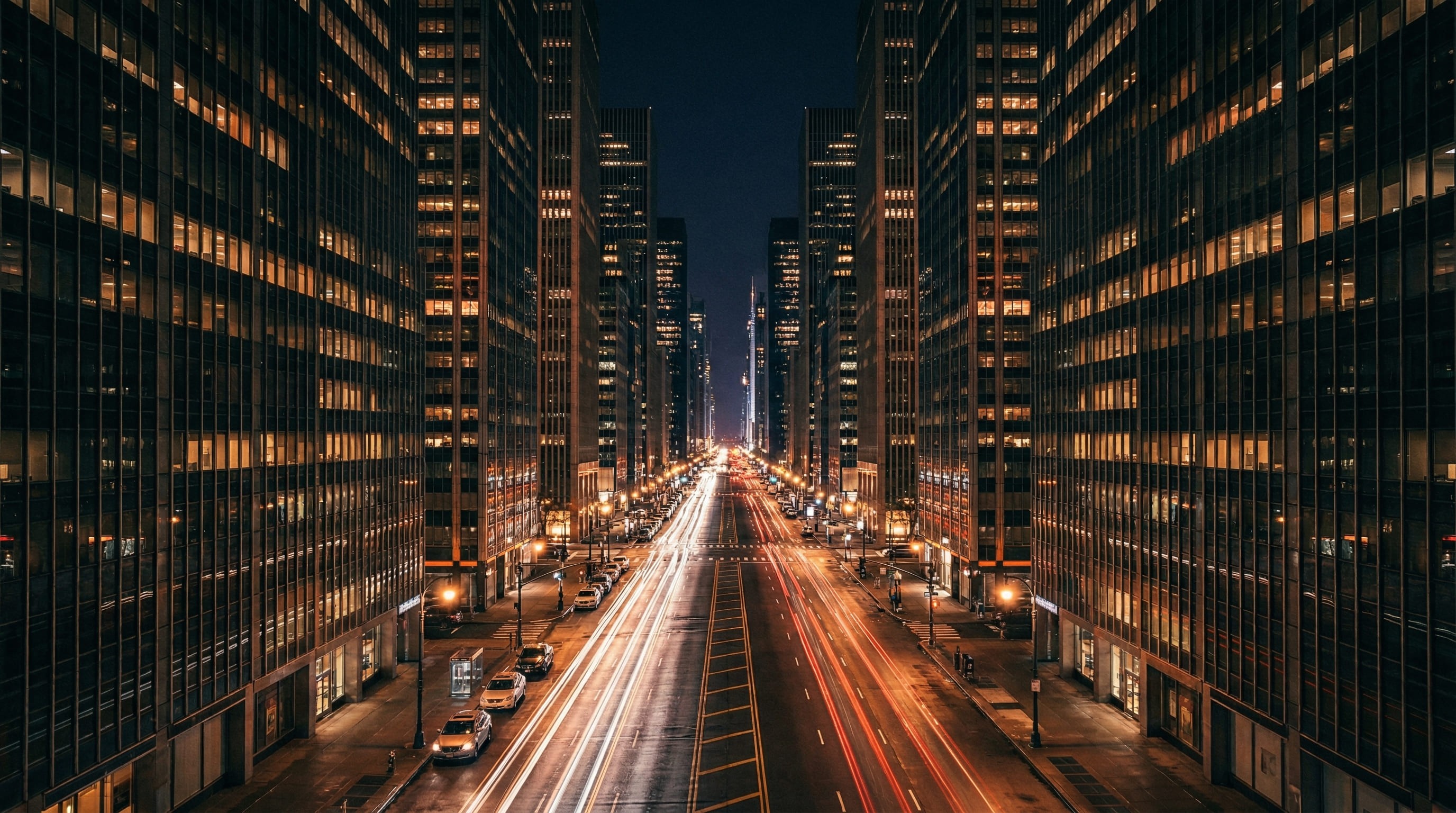 City street at night with light trails from cars.