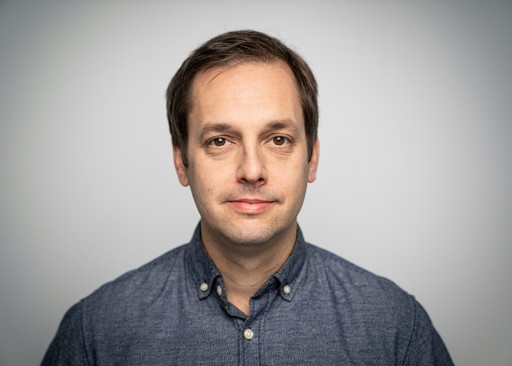 a man in a blue shirt is posing for a picture