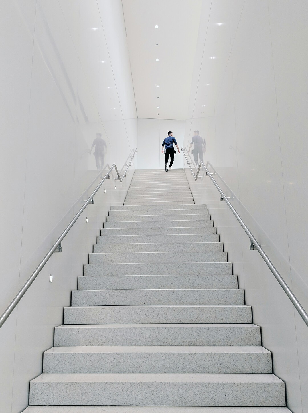 A tall white staircase with a man at the top