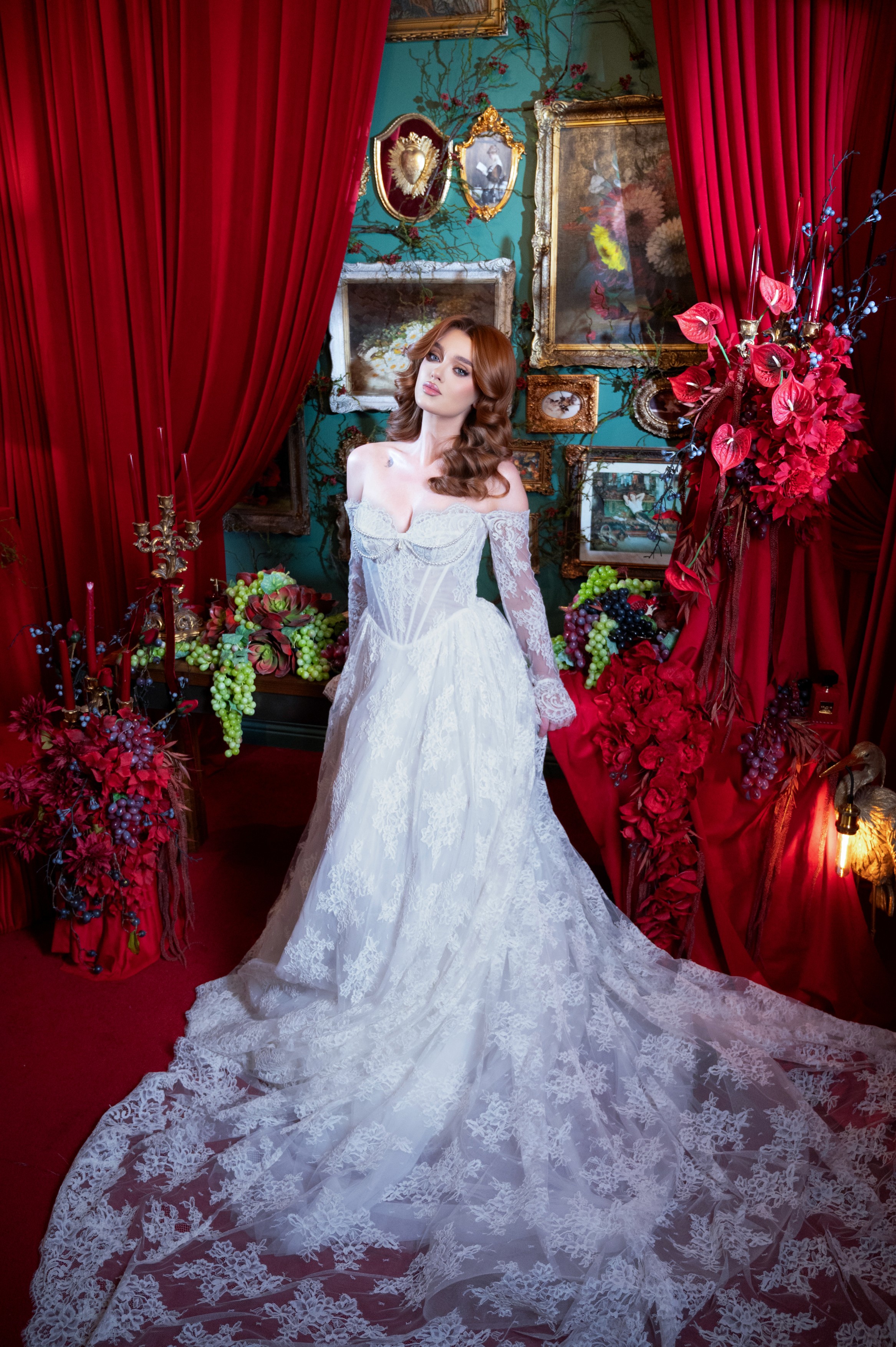 Mireasă în rochie elegantă fotografiată într-un decor dramatic cu drapaje roșii și flori, ședință foto de nuntă în București