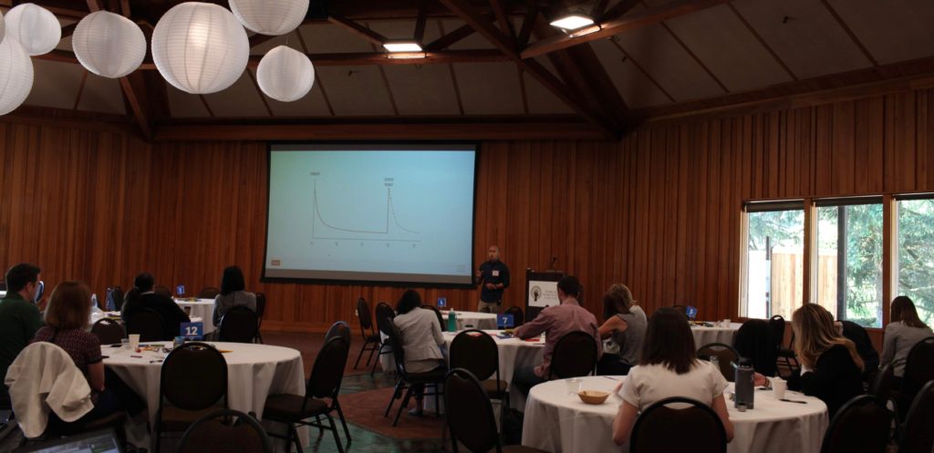 Eric Lam presents at ILN in front of a room of healthcare innovators.