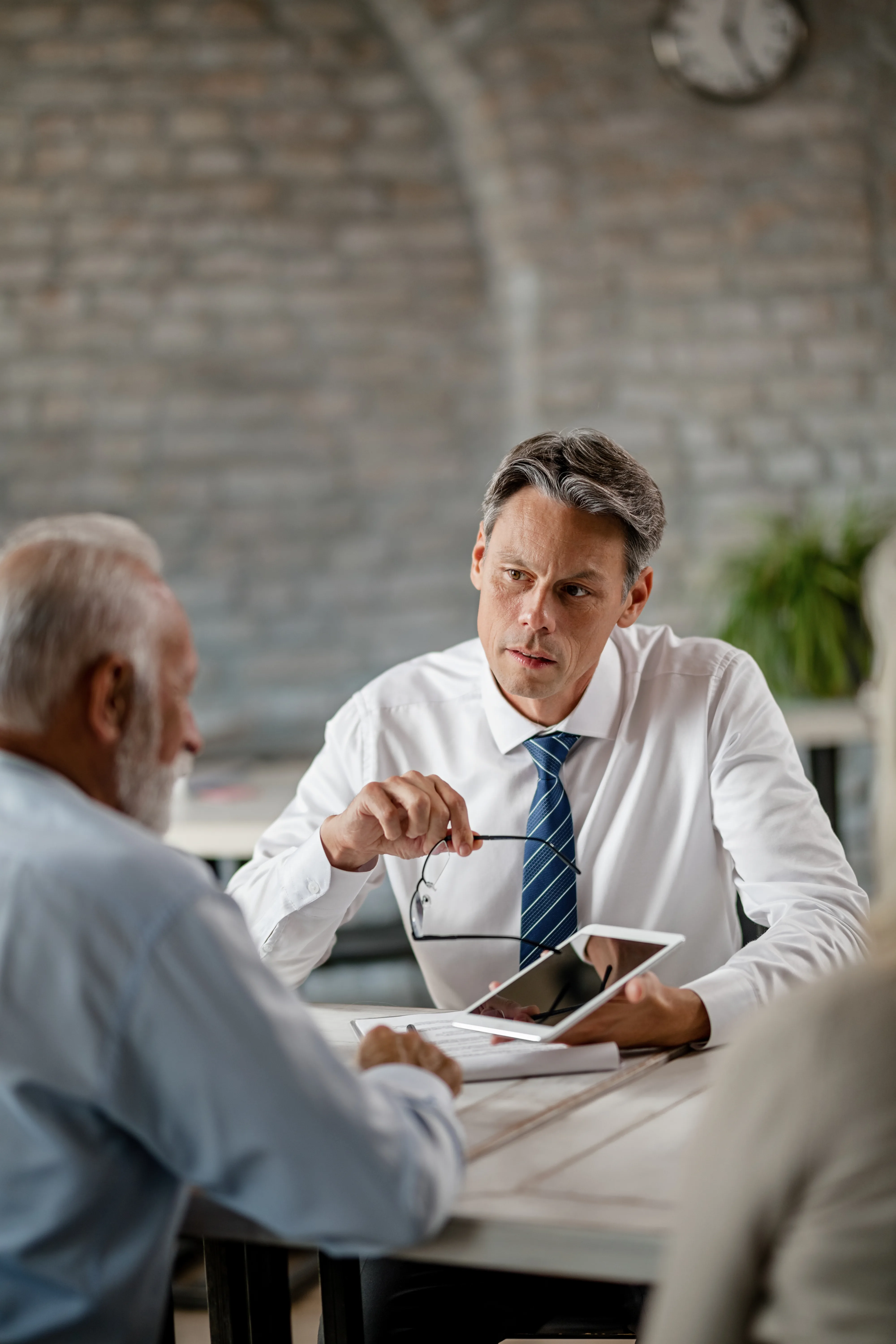 Enterprise meeting between executives discussing AI governance strategy, operational oversight, and business risk management.