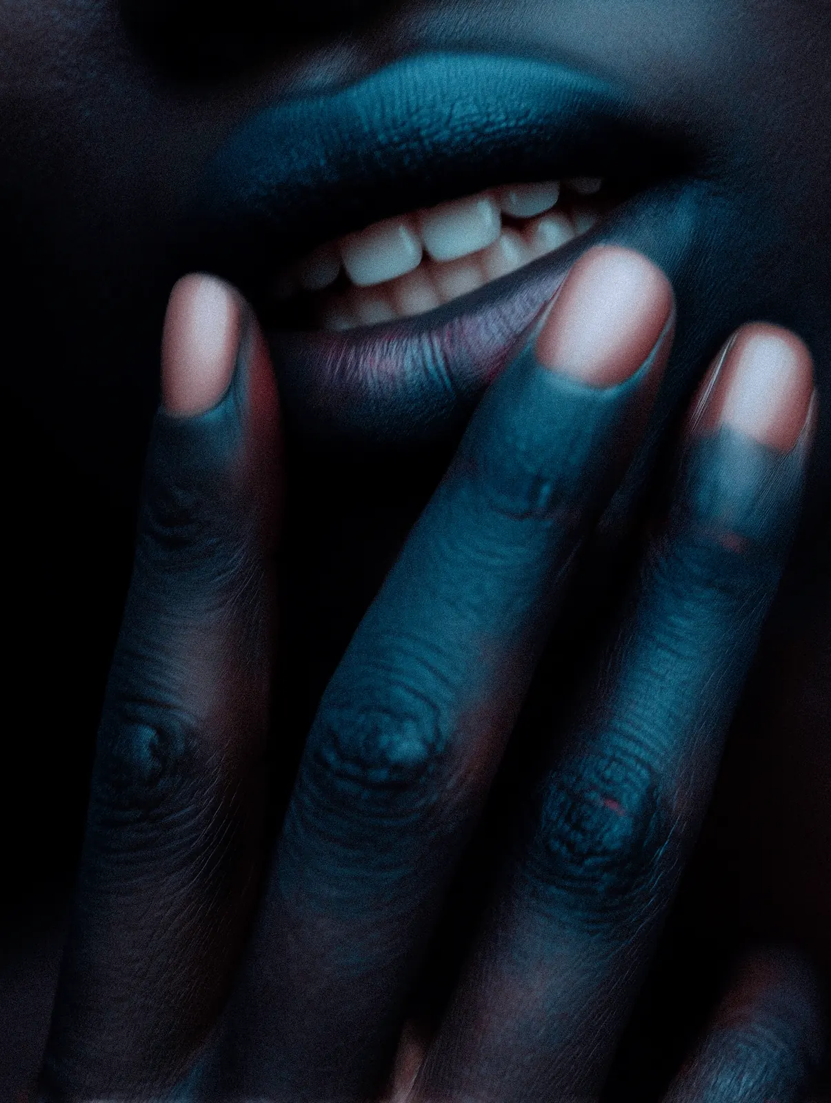 Close-up of a smiling mouth with a hand below the lips in blue light.