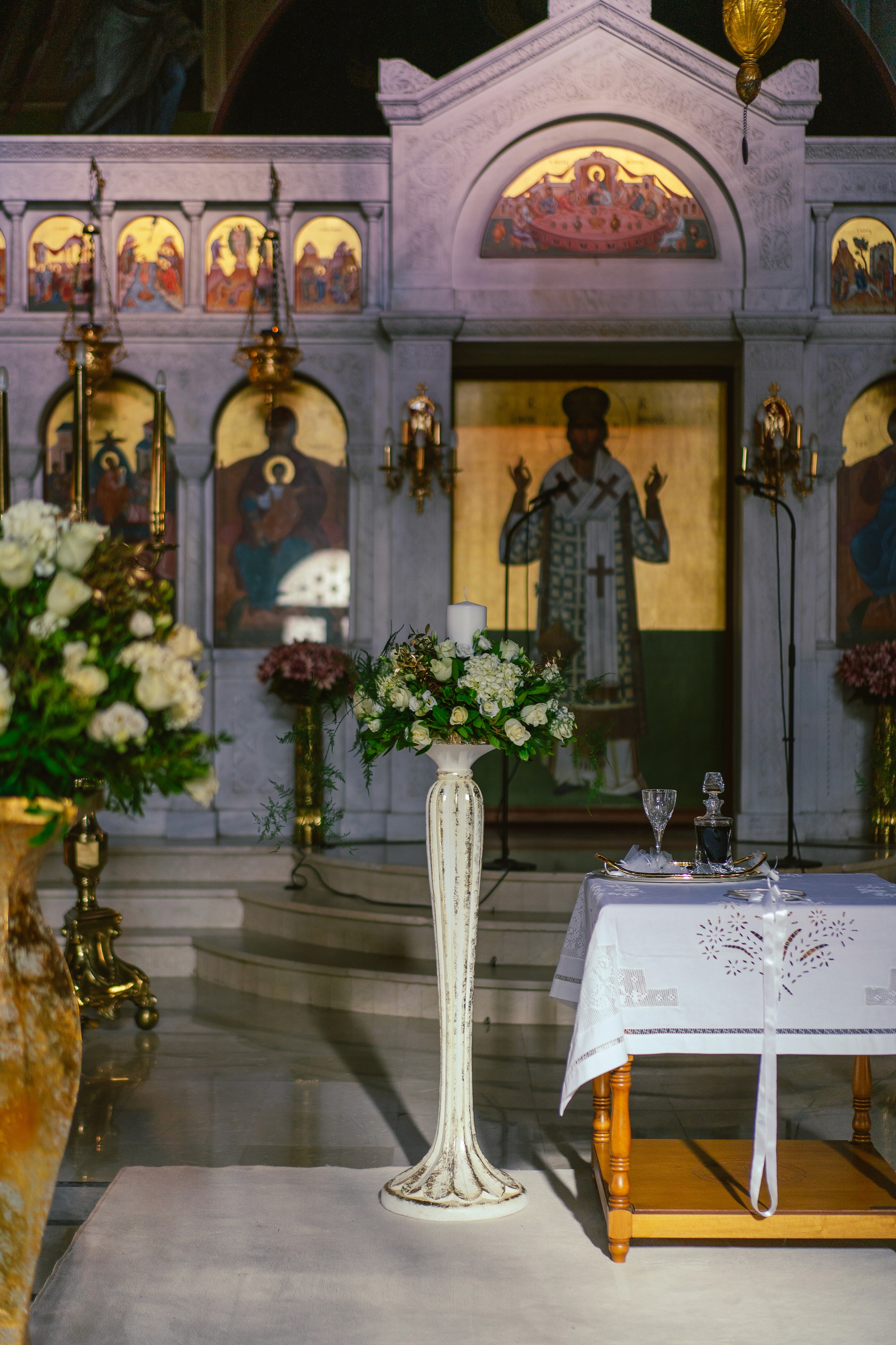 Κομψός στολισμός λαμπάδας γάμου σε λευκή βάση με κλασικά λευκά λουλούδια