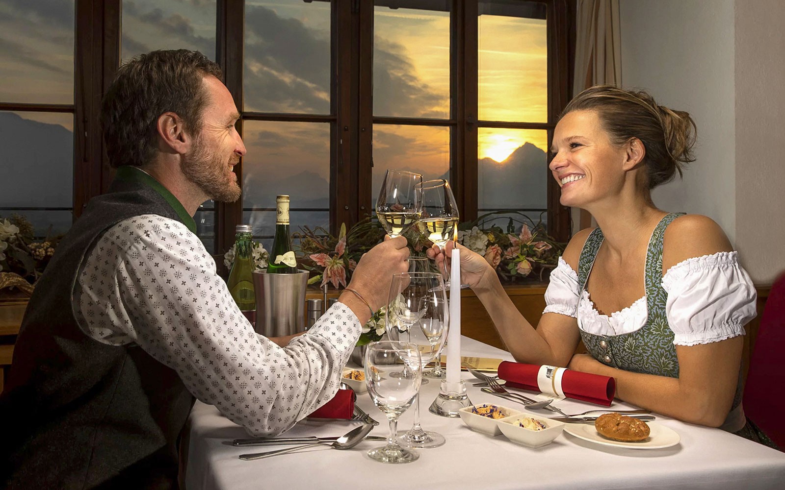 Couple toasting with wine at sunset dinner, Salzburg.