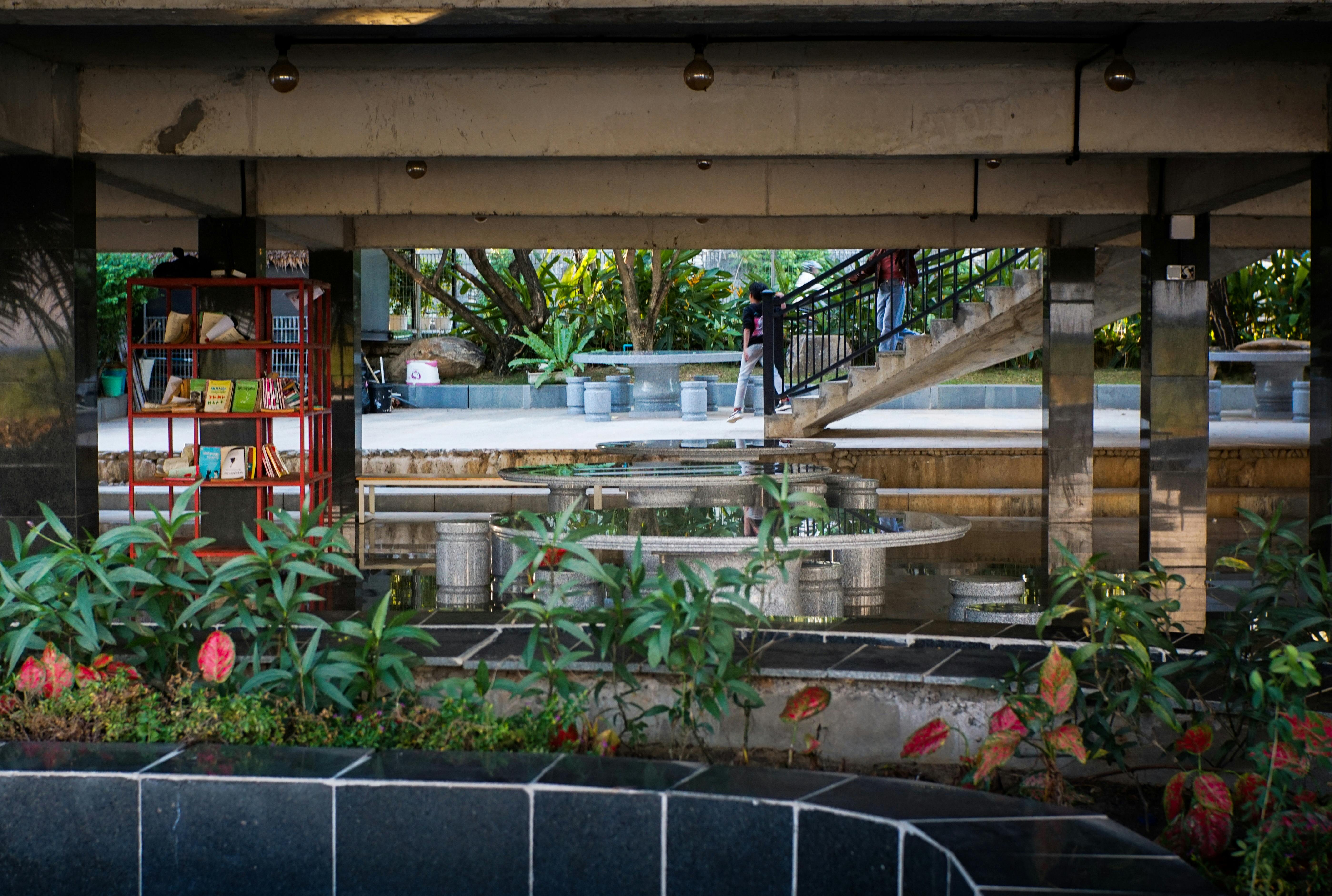 Shaded outdoor reading corner with planting and seating illustrating a small public space intervention that supports dwell time and place identity in Phnom Penh