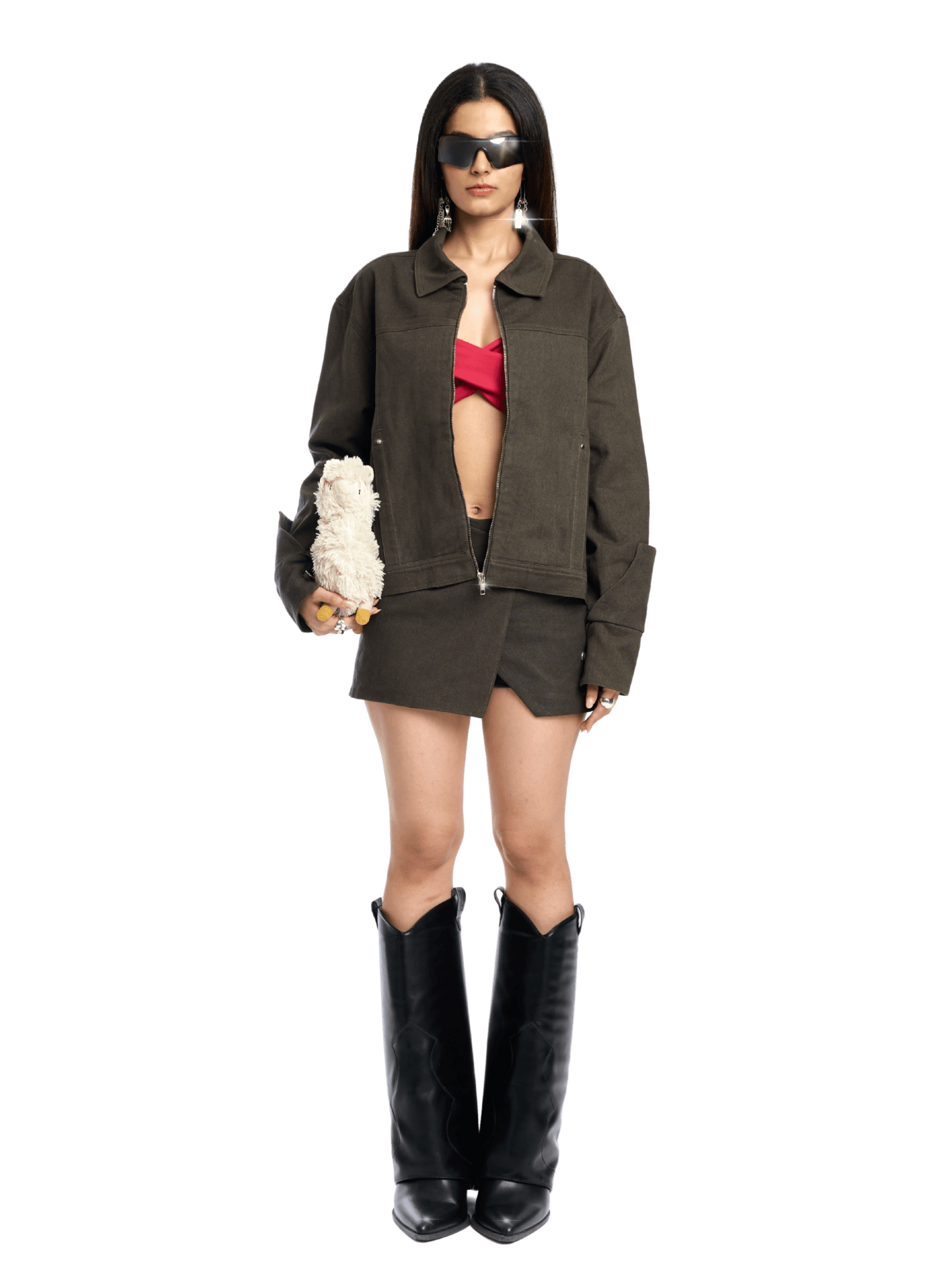 Woman wearing a green jacket, red top, and black boots on a white background