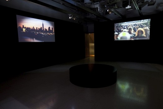 projection of a sunset cityscape and another of a crowded street