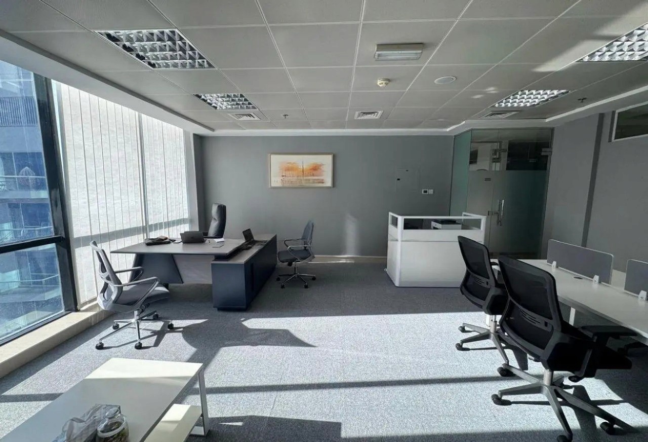 Modern open-plan office space for rent, featuring natural light and sleek workstations inside the tower.