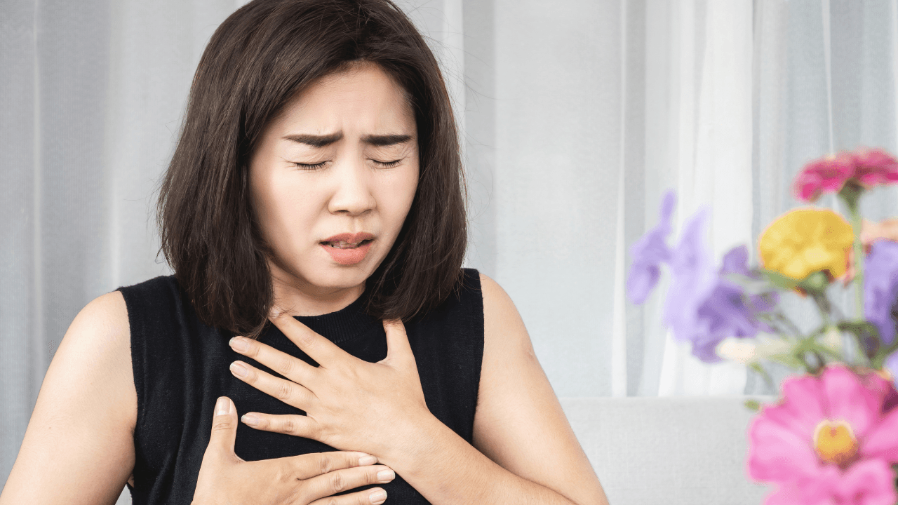 A woman with both hands in her chest having a hard time breathing